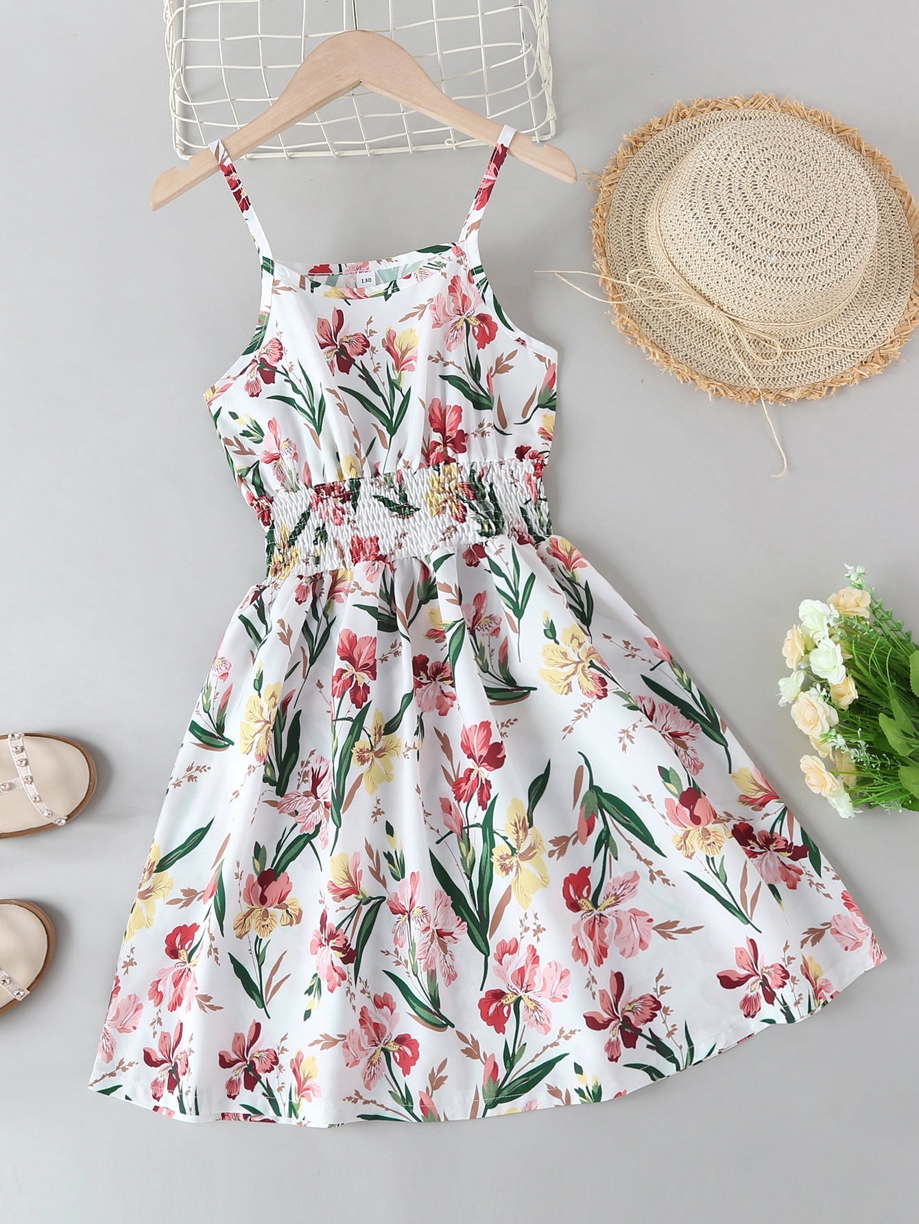 Tween girls floral mini dress with spaghetti straps, ruched shirred bodice, frill details, ruffle hem, high waist, and flared short silhouette for summer casual wear.