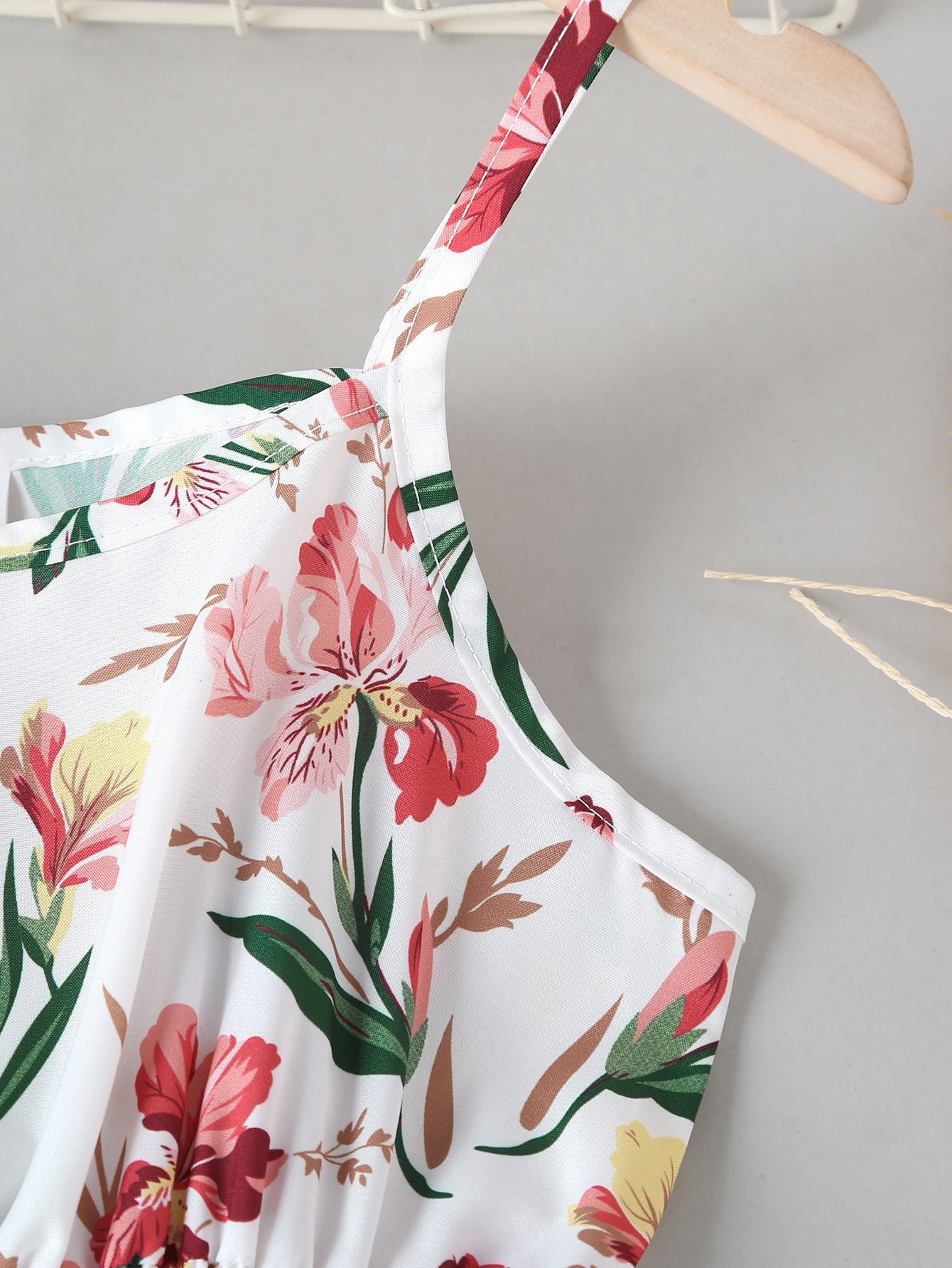 Tween girls floral mini dress with spaghetti straps, ruched shirred bodice, frill details, ruffle hem, high waist, and flared short silhouette for summer casual wear.
