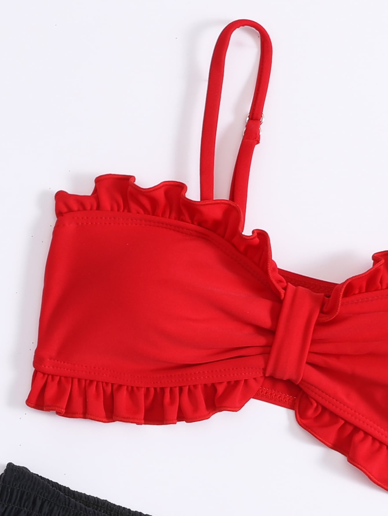 Red tween girls bikini set with a colorblock design, smocked detailing, and frill trim. Includes a wireless spaghetti strap bikini top and lined mid-waist bikini bottoms with slight stretch.