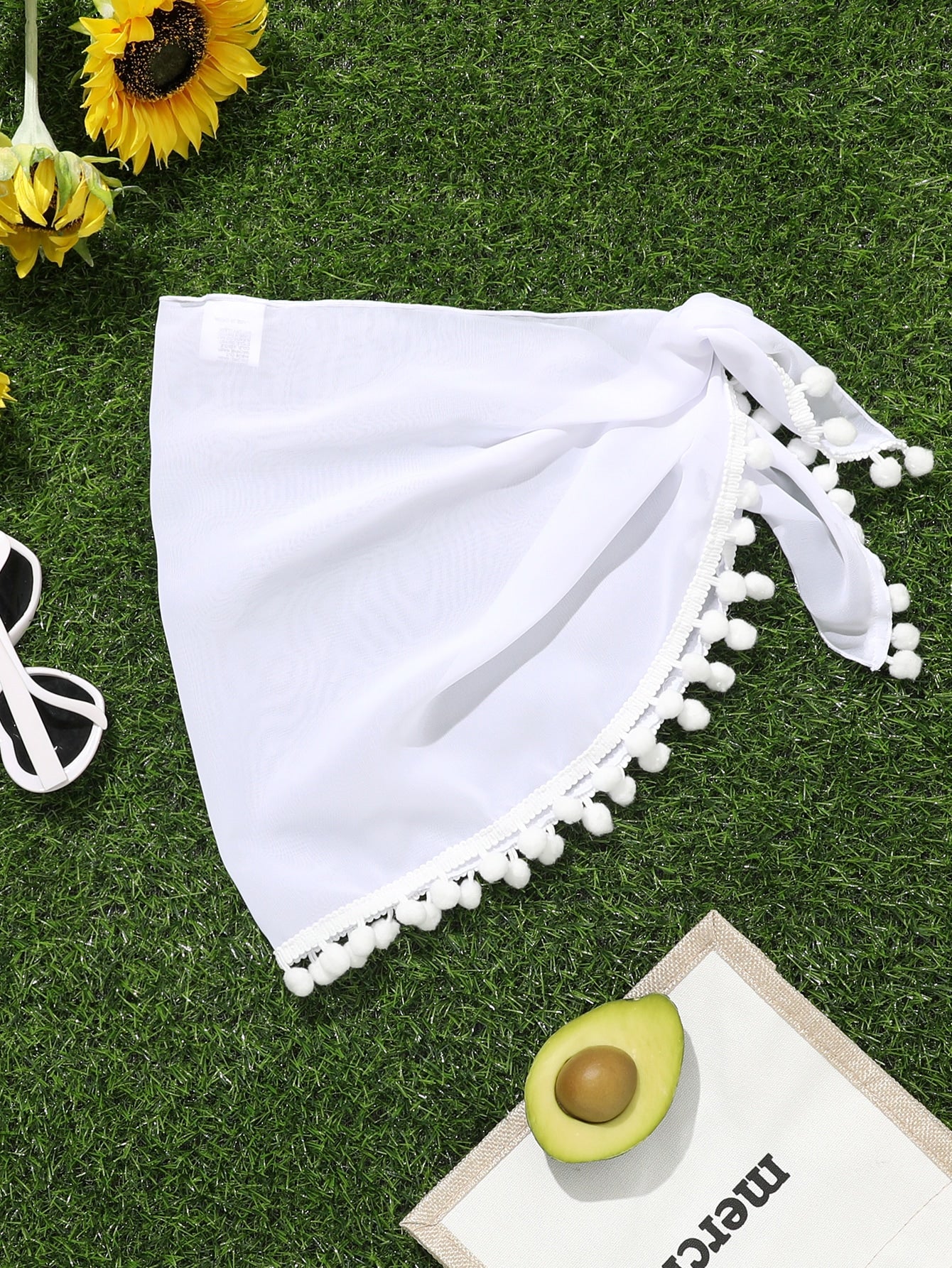 White tween girls cover up skirt with knot side, pom pom trim, asymmetrical hem, long semi-sheer design, and plain summer beachwear style.
