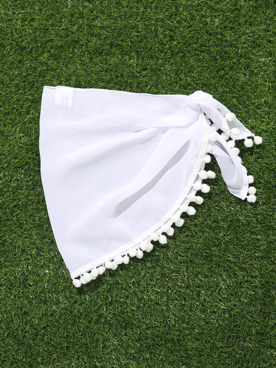 White tween girls cover up skirt with knot side, pom pom trim, asymmetrical hem, long semi-sheer design, and plain summer beachwear style.