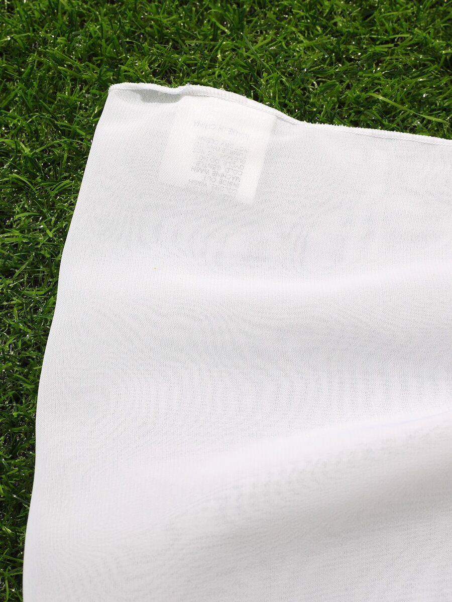 White tween girls cover up skirt with knot side, pom pom trim, asymmetrical hem, long semi-sheer design, and plain summer beachwear style.