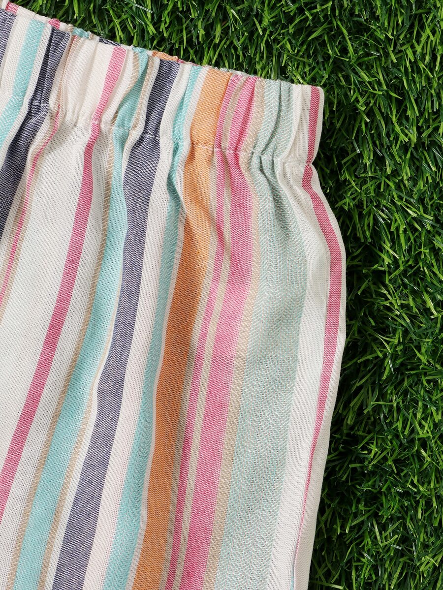 Tween girl wearing a multicolor rainbow striped camisole top with spaghetti straps and matching boho shorts.