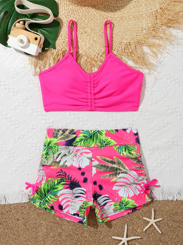 Tween girl tropical print ruched bikini set with spaghetti strap top and shorts-style bottoms, wireless design, high-stretch fabric, shown in hot pink.