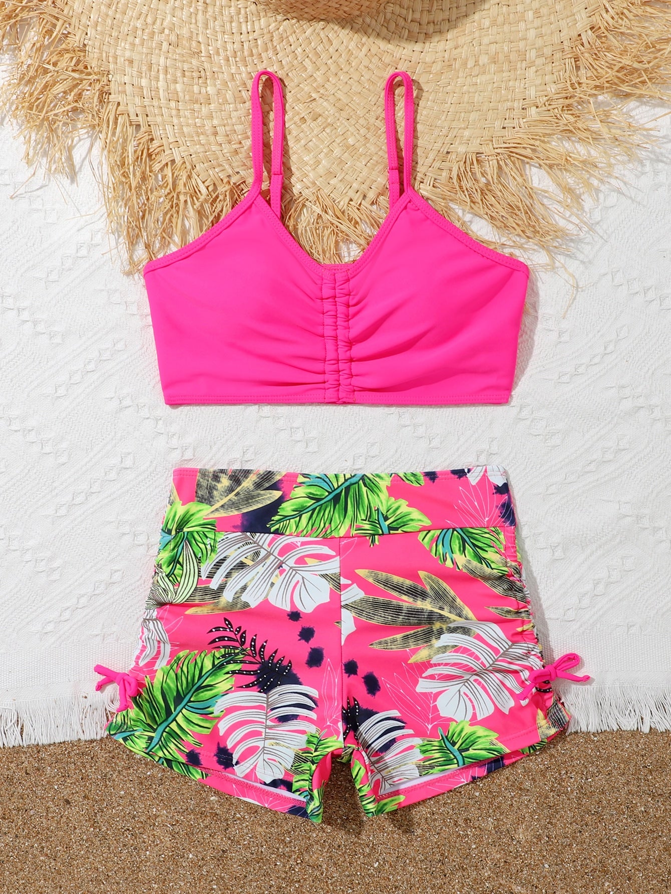 Tween girl tropical print ruched bikini set with spaghetti strap top and shorts-style bottoms, wireless design, high-stretch fabric, shown in hot pink.