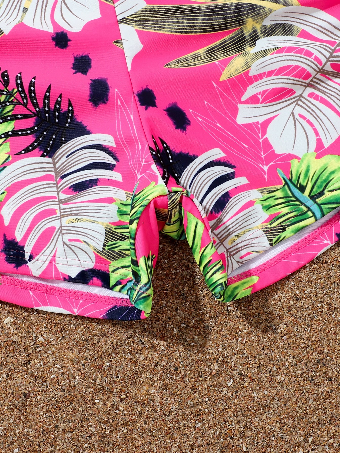 Tween girl tropical print ruched bikini set with spaghetti strap top and shorts-style bottoms, wireless design, high-stretch fabric, shown in hot pink.