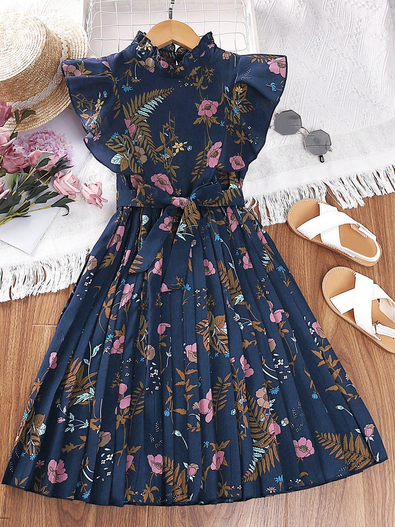 Tween girl wearing navy blue floral print ruffle trim belted pleated mini dress with stand collar and flounce cap sleeves