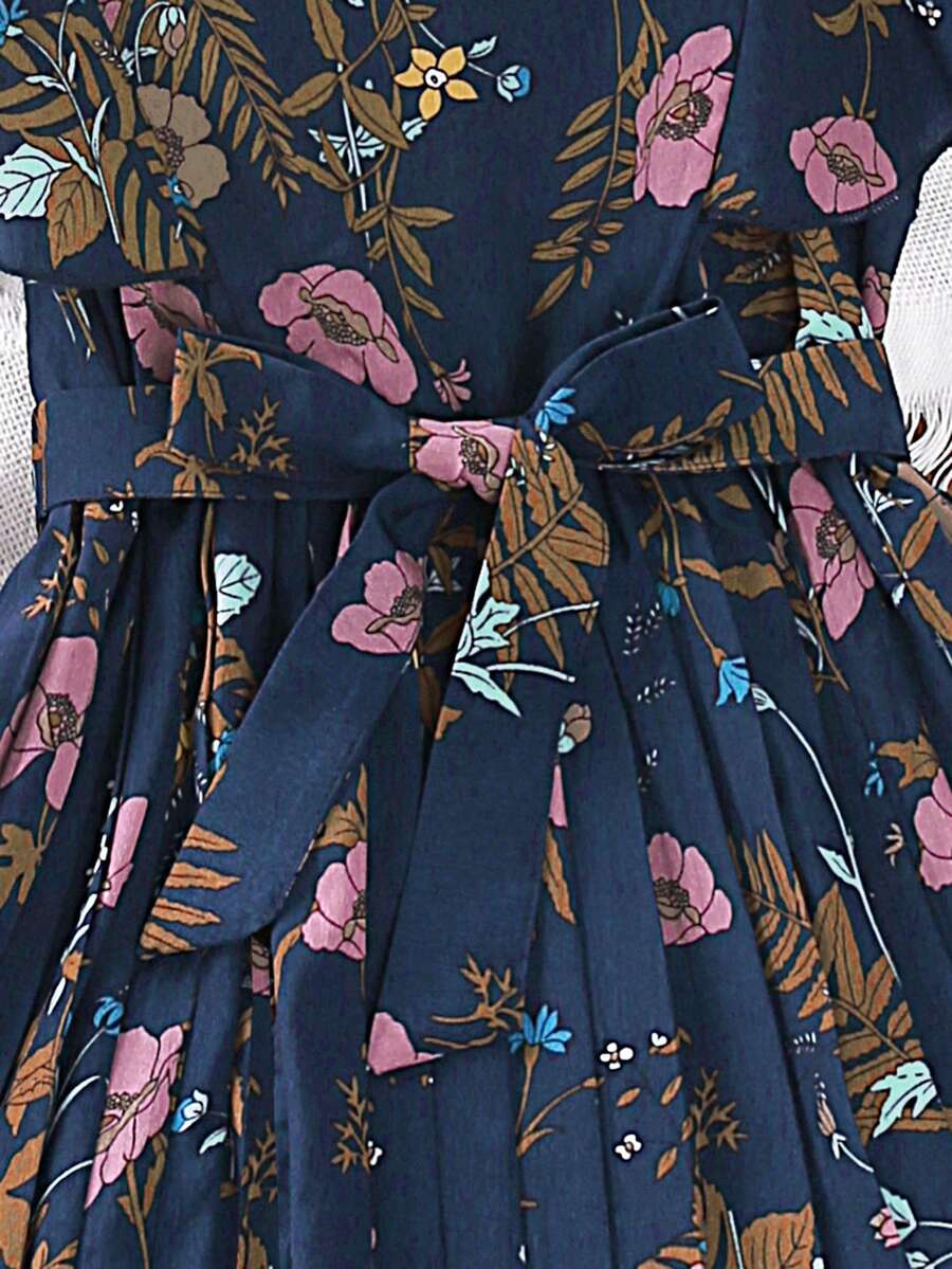 Tween girl wearing navy blue floral print ruffle trim belted pleated mini dress with stand collar and flounce cap sleeves