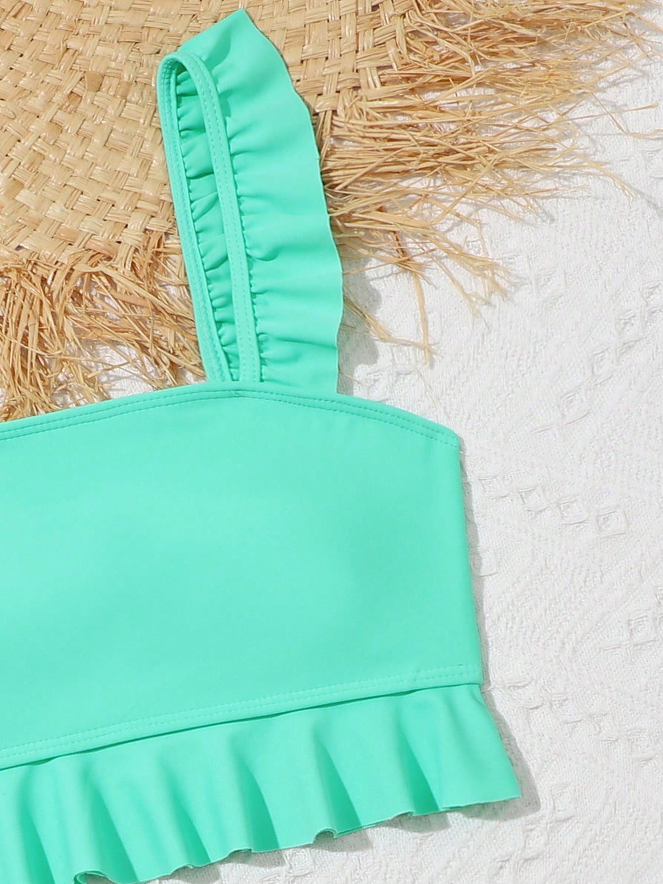 Tween girls solid color 2-piece bikini swimwear set with ruffle detail, strap neckline, wireless bikini top, and triangle mid-waist bikini bottoms; textured pattern with lined bottoms and high-stretch fabric, suitable for summer vacation.