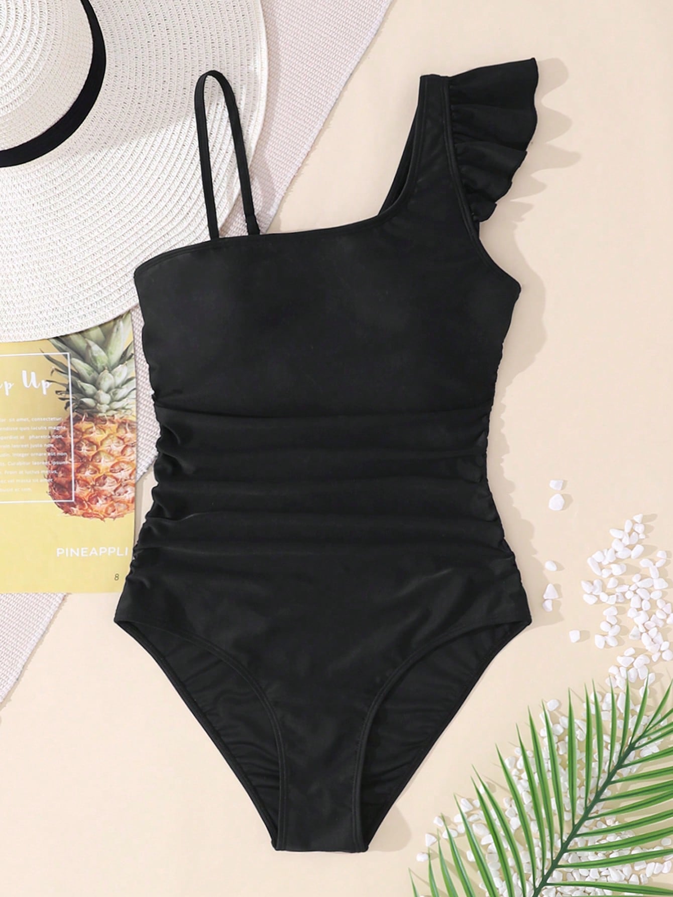 Tween girl one-piece swimsuit in brown polka dot geometric print with asymmetrical neckline, ruffle detail, cut-out design, and fitted mid-waist swim bottom.