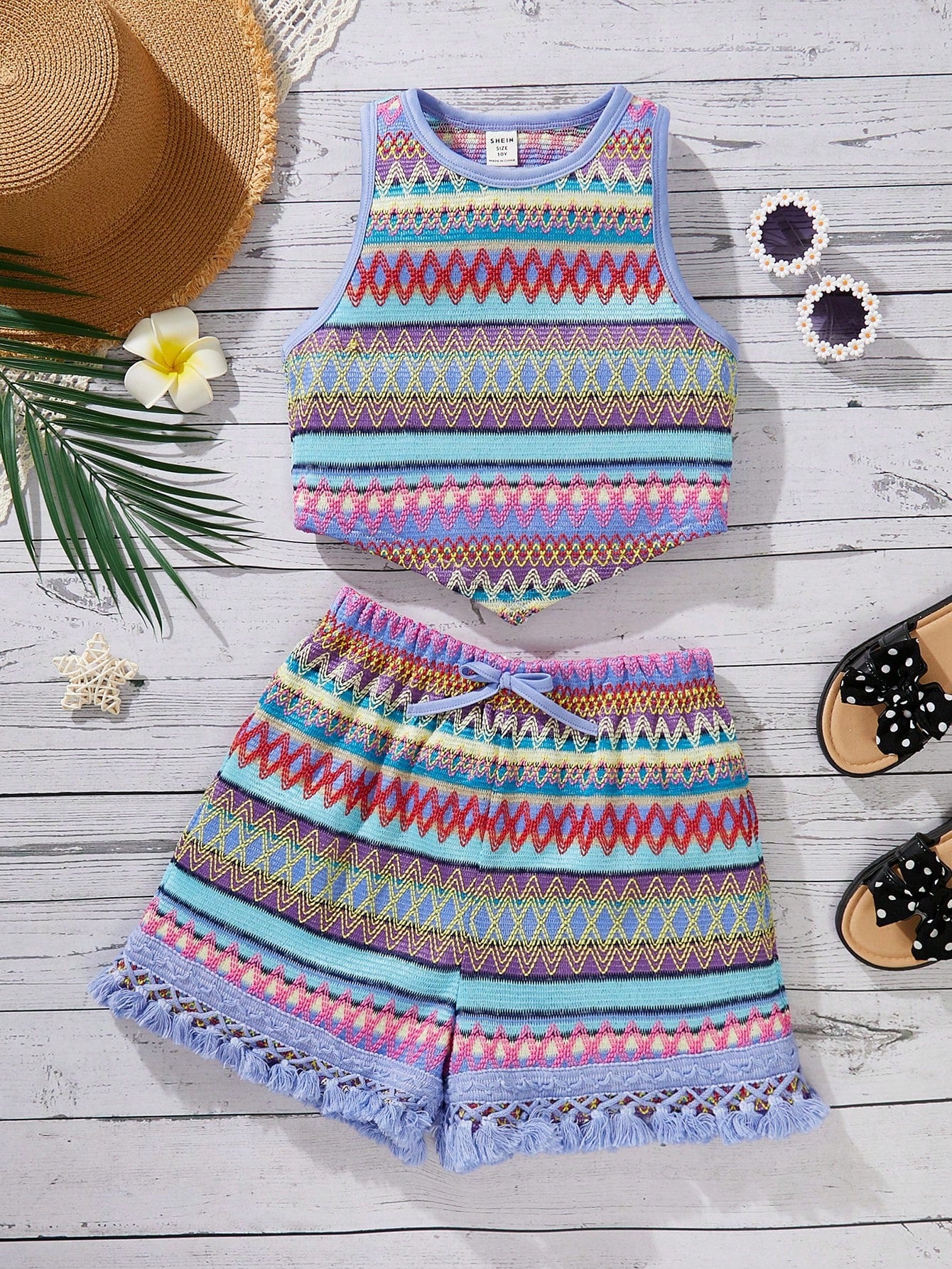 Tween girl wearing a blue boho sleeveless round neck tank top and matching printed shorts set with cable knit detailing.