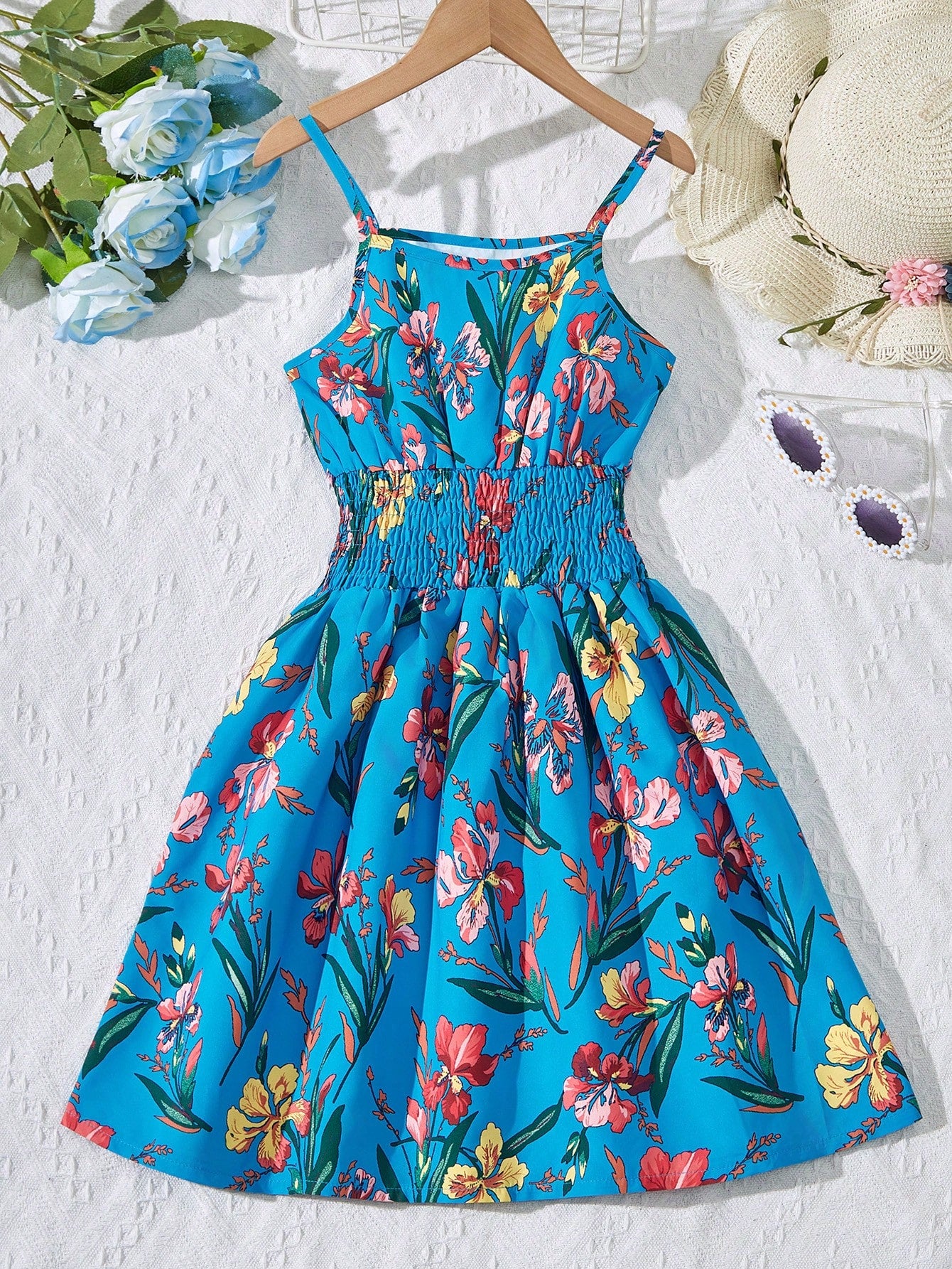 Tween girls floral mini dress with spaghetti straps, ruched shirred bodice, frill details, ruffle hem, high waist, and flared short silhouette for summer casual wear.