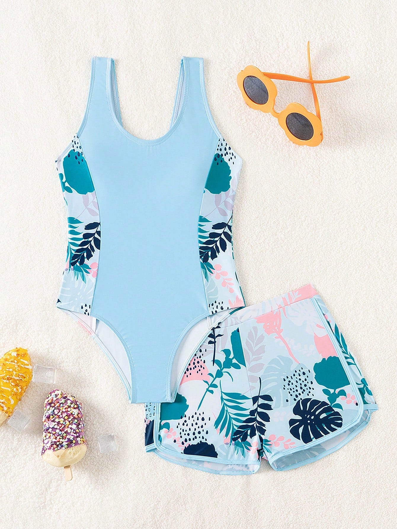 Tween girls 2-piece swimsuit set with a printed one-piece featuring ruffle trim, scoop neckline, cut-out detail, and matching shorts bottom.
