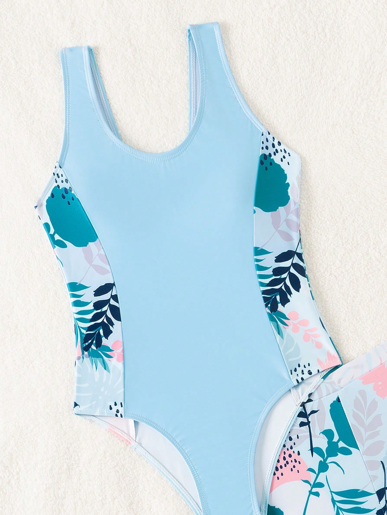 Tween girls 2-piece swimsuit set with a printed one-piece featuring ruffle trim, scoop neckline, cut-out detail, and matching shorts bottom.