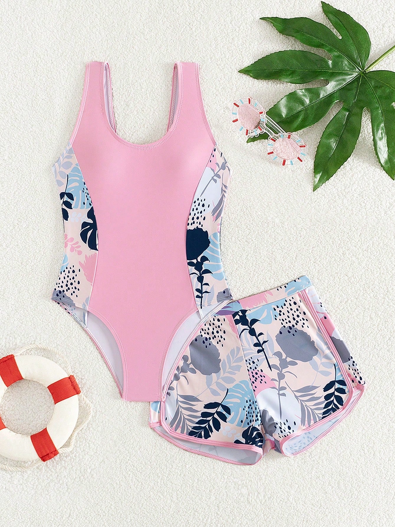 Tween girls 2-piece swimsuit set with a printed one-piece featuring ruffle trim, scoop neckline, cut-out detail, and matching shorts bottom.
