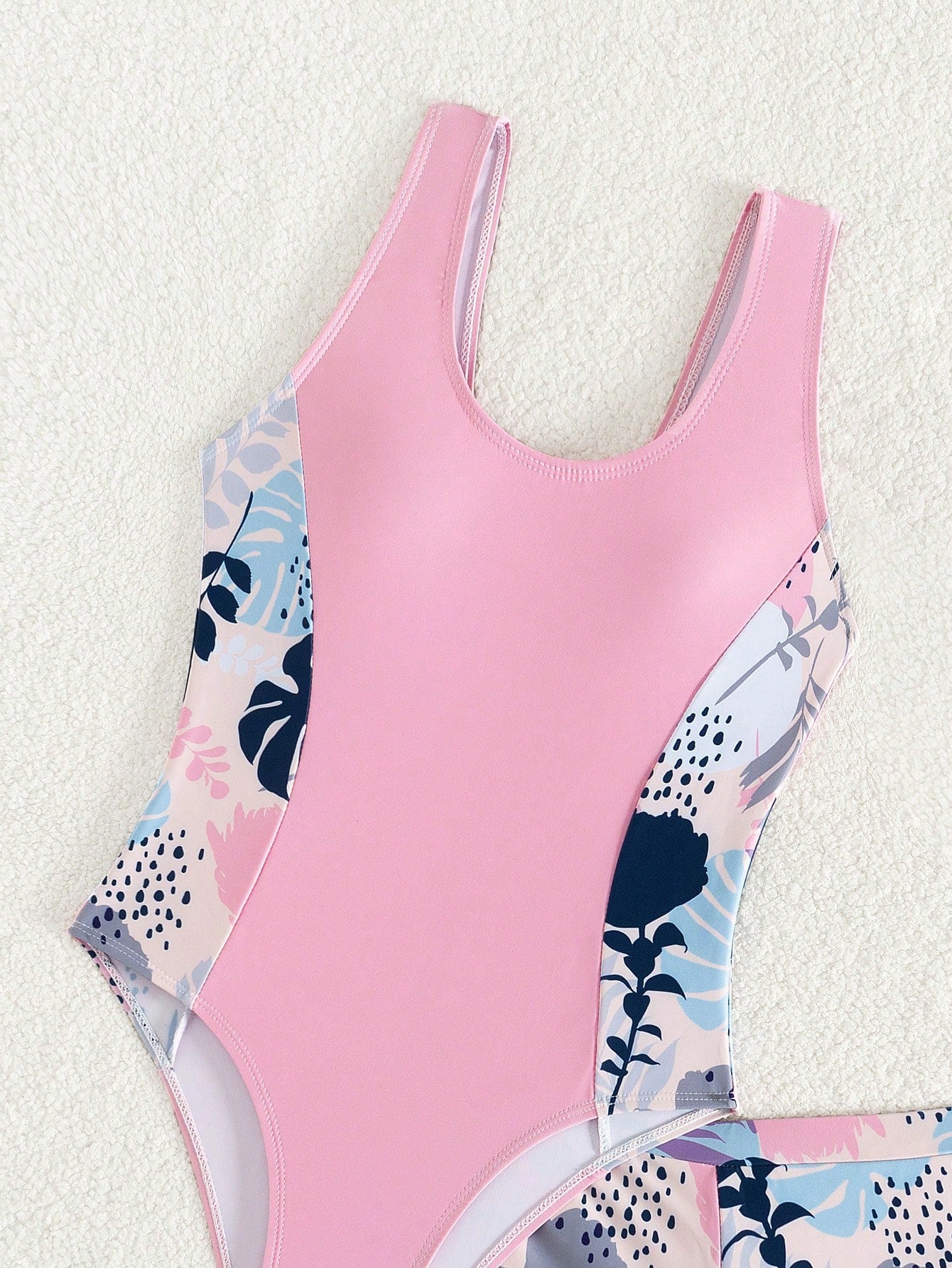 Tween girls 2-piece swimsuit set with a printed one-piece featuring ruffle trim, scoop neckline, cut-out detail, and matching shorts bottom.