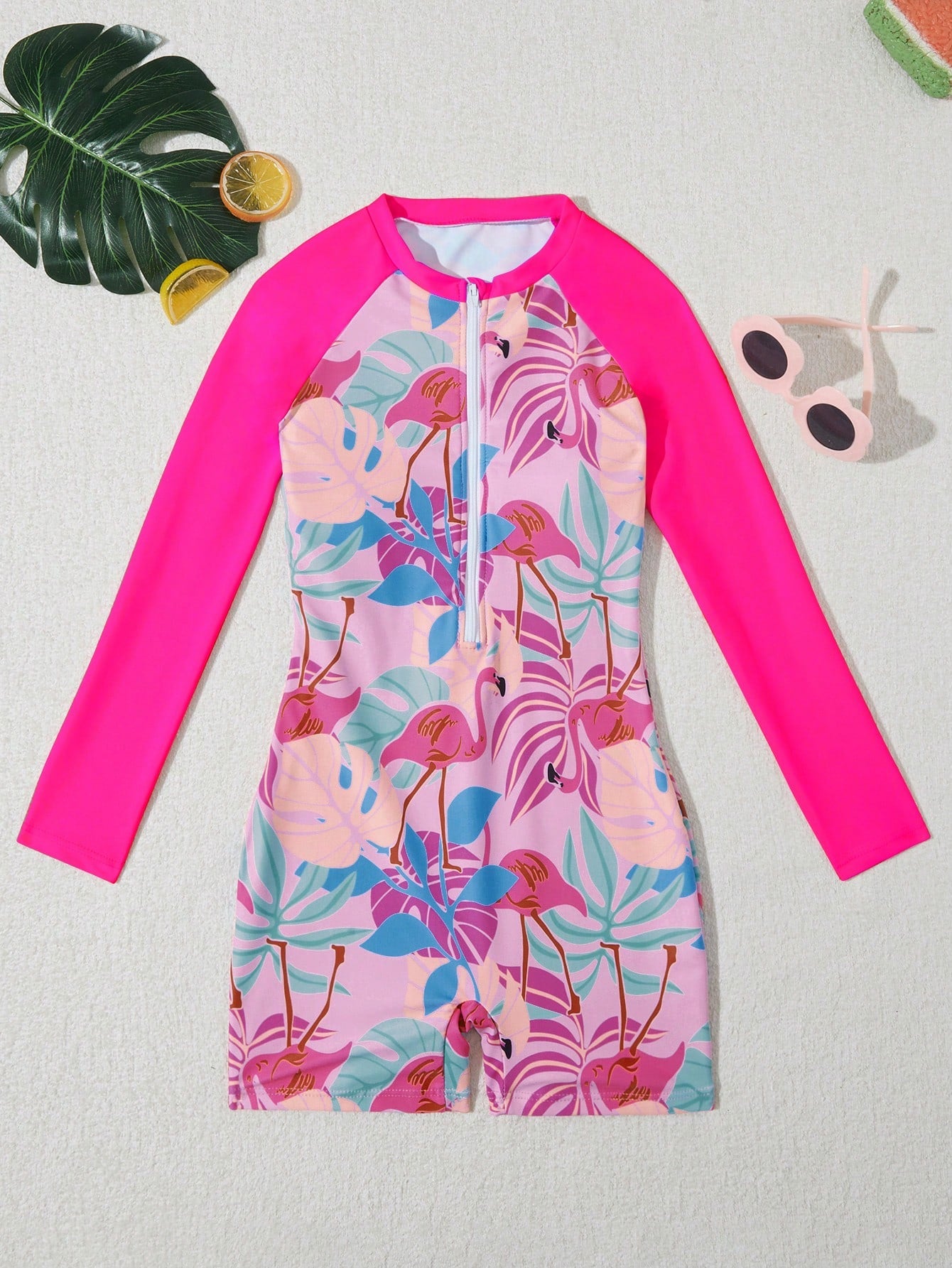 Tween girls one-piece swimsuit featuring a high neck, long sleeves, and shorts bottom, with a back zipper and strawberry plaid digital print on stretch knit fabric. Designed for swimming, vacation, and summer wear.