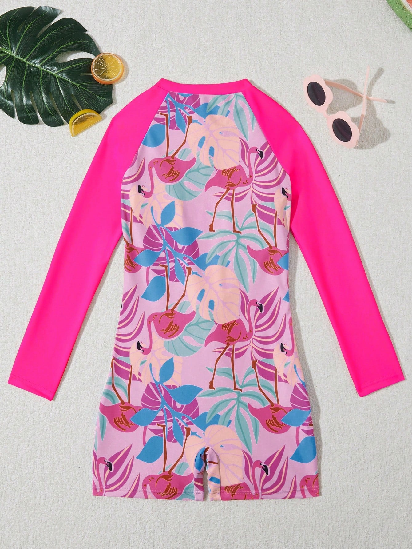 Tween girls one-piece swimsuit featuring a high neck, long sleeves, and shorts bottom, with a back zipper and strawberry plaid digital print on stretch knit fabric. Designed for swimming, vacation, and summer wear.