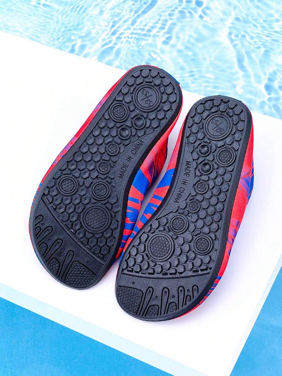 Red slip-on boys water shoes featuring a breathable fabric upper with contrast binding and a durable TPR outsole.