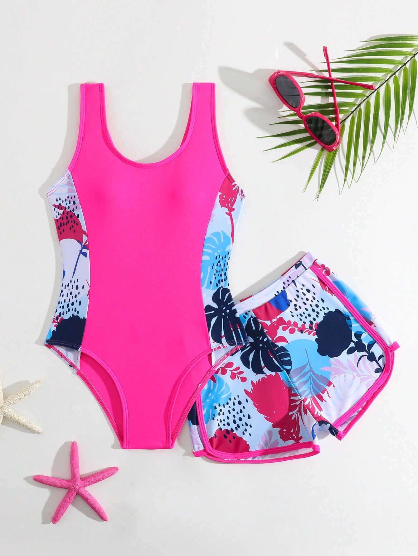 Tween girls 2-piece swimsuit set with a printed one-piece featuring ruffle trim, scoop neckline, cut-out detail, and matching shorts bottom.