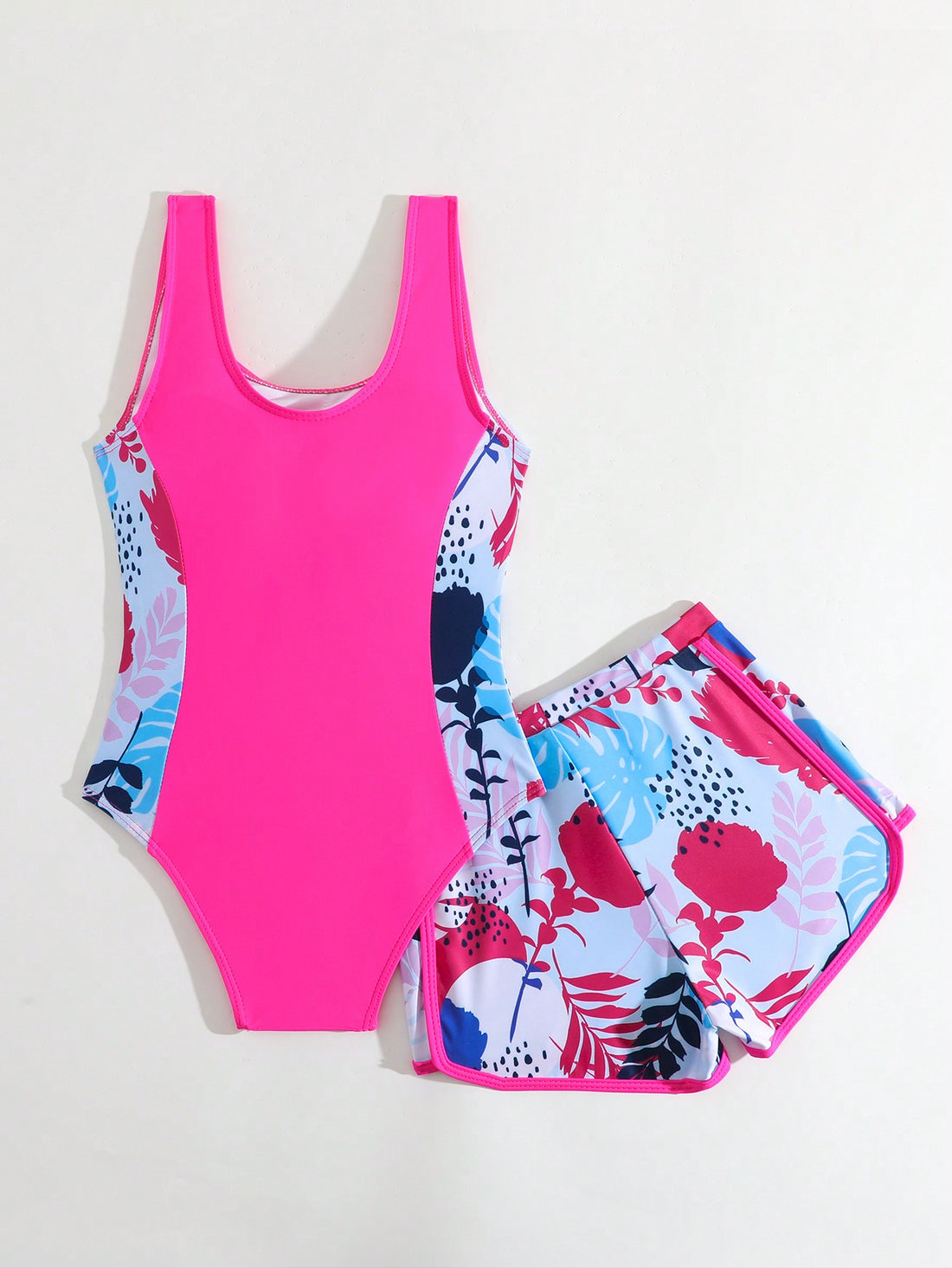 Tween girls 2-piece swimsuit set with a printed one-piece featuring ruffle trim, scoop neckline, cut-out detail, and matching shorts bottom.
