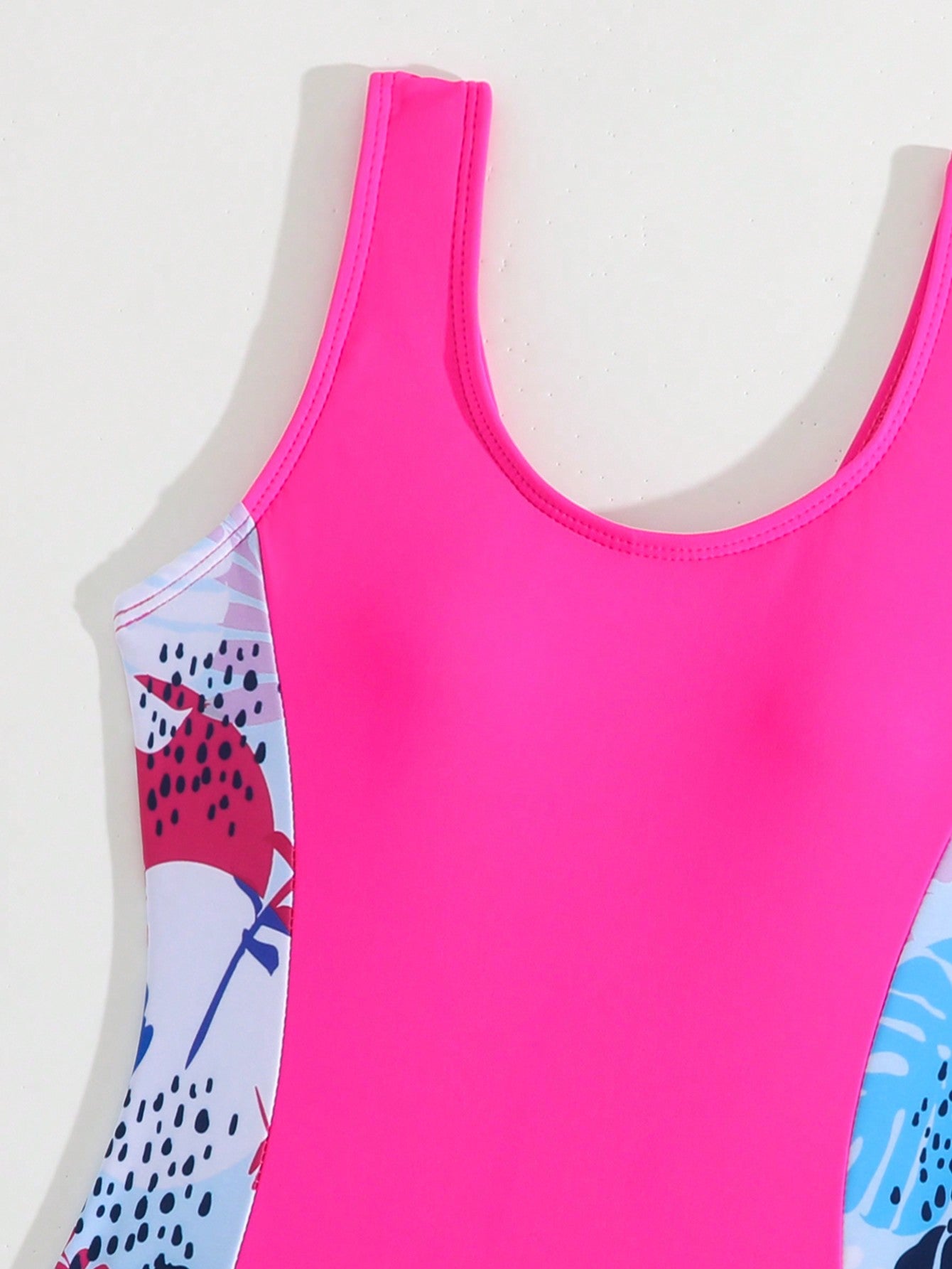 Tween girls 2-piece swimsuit set with a printed one-piece featuring ruffle trim, scoop neckline, cut-out detail, and matching shorts bottom.