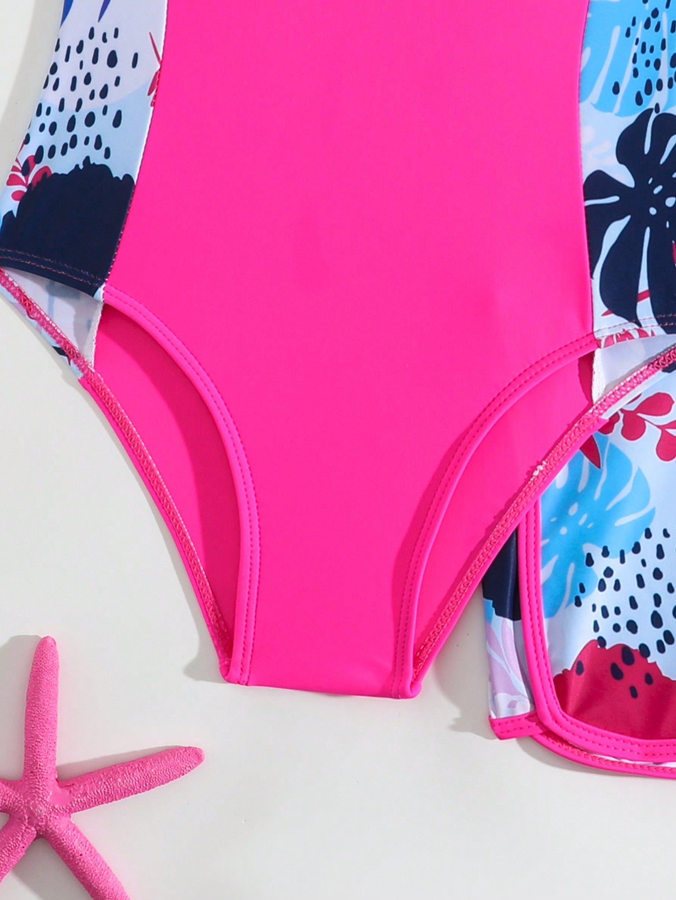 Tween girls 2-piece swimsuit set with a printed one-piece featuring ruffle trim, scoop neckline, cut-out detail, and matching shorts bottom.