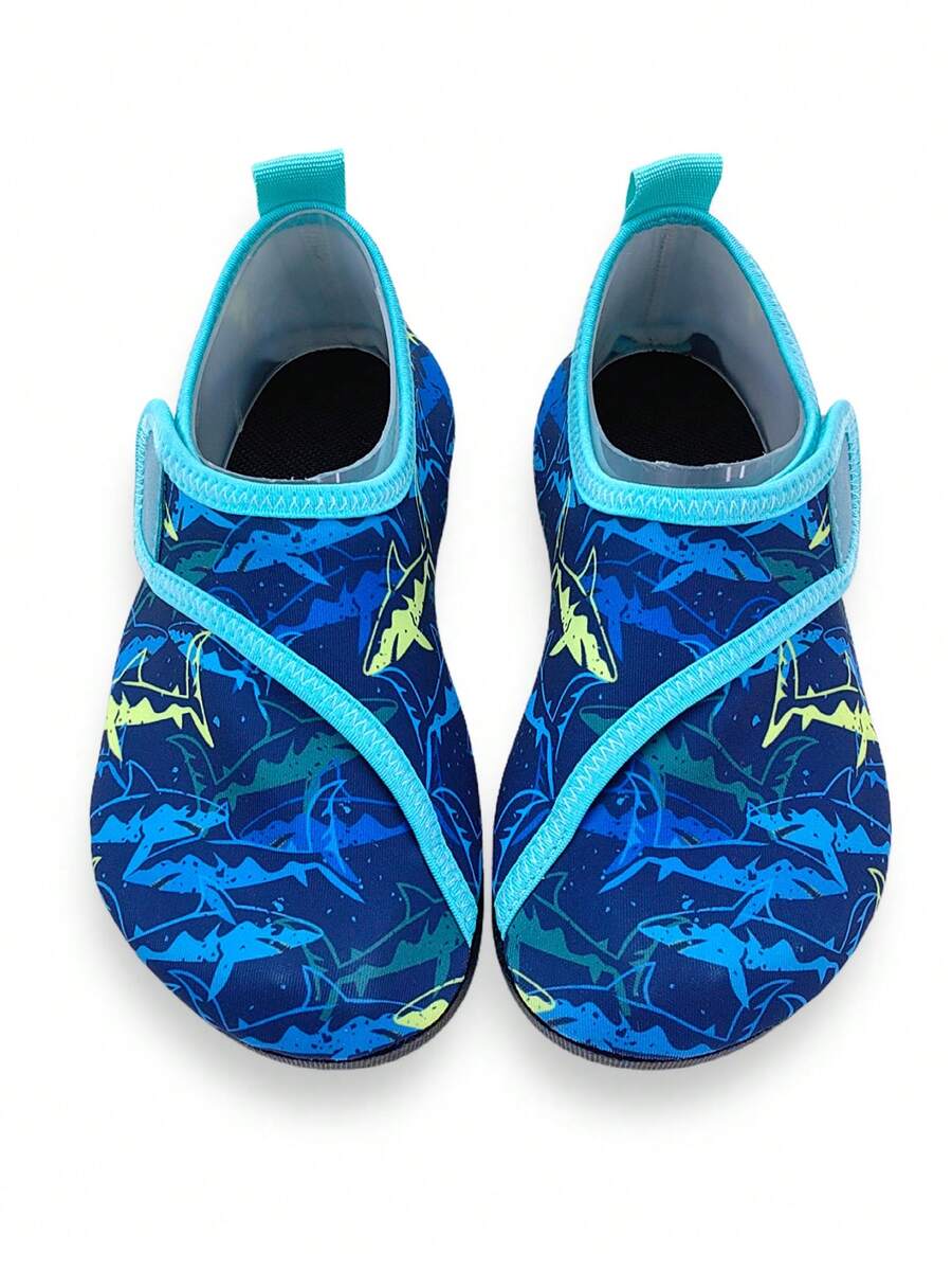 Blue kids water shoes with a shark print pattern, breathable fabric upper, and secure hook and loop closure.