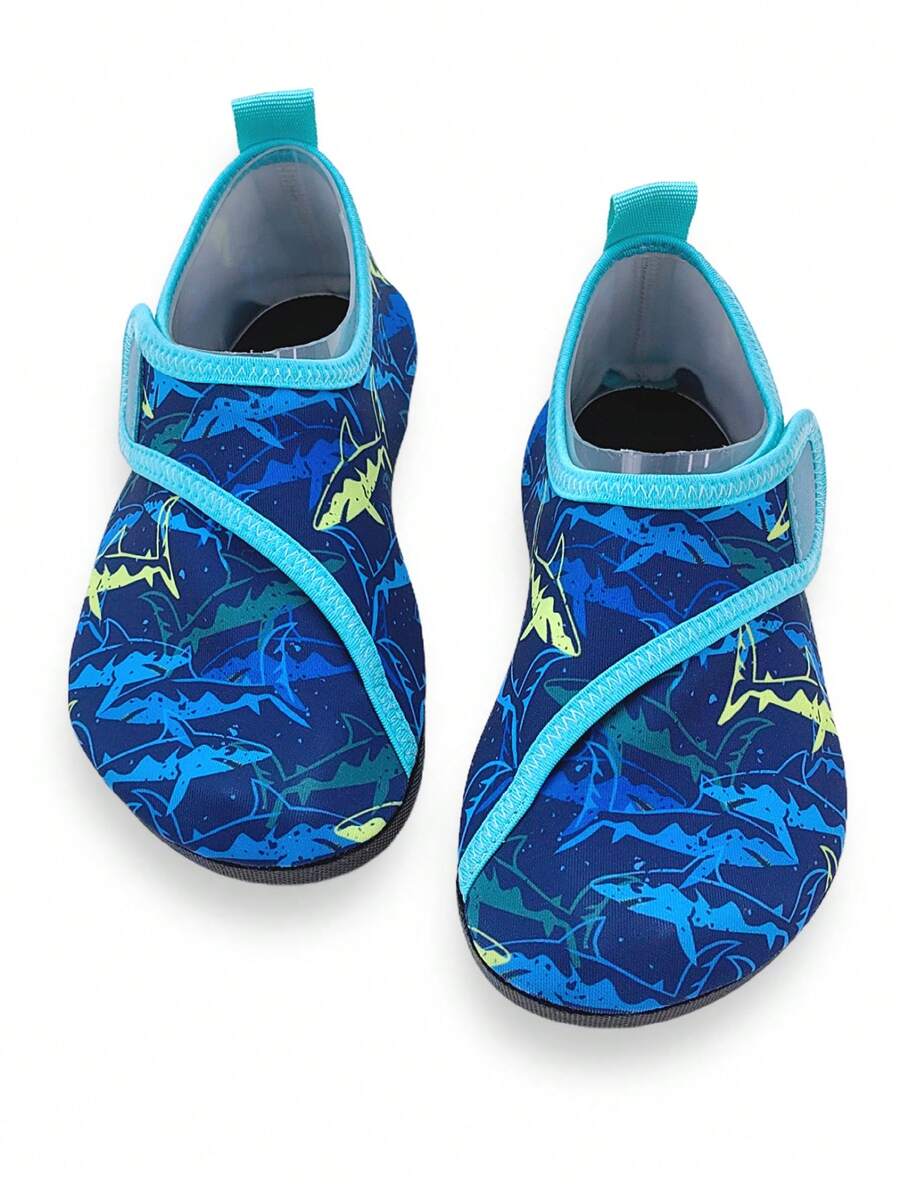 Blue kids water shoes with a shark print pattern, breathable fabric upper, and secure hook and loop closure.