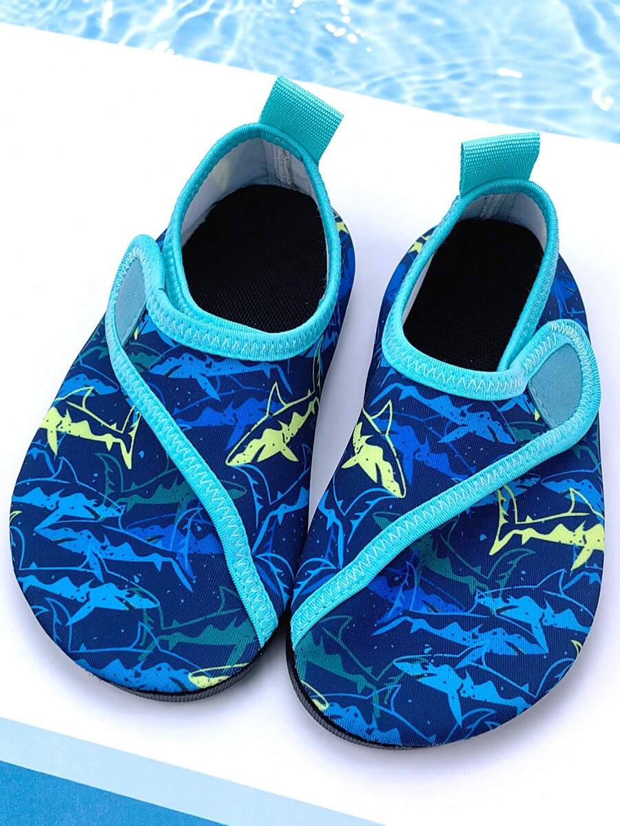 Blue kids water shoes with a shark print pattern, breathable fabric upper, and secure hook and loop closure.