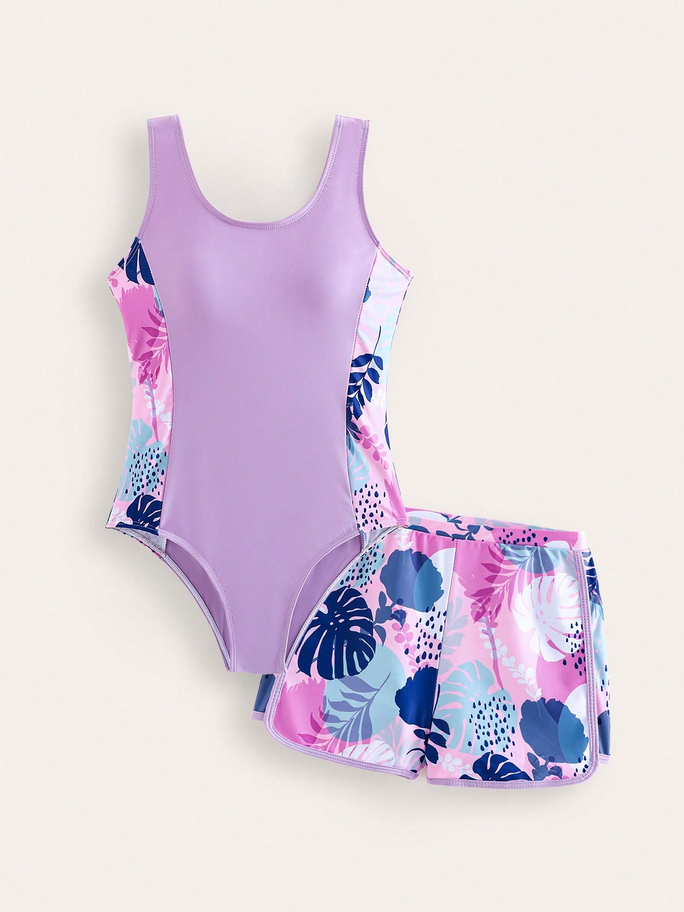 Tween girls 2-piece swimsuit set with a printed one-piece featuring ruffle trim, scoop neckline, cut-out detail, and matching shorts bottom.