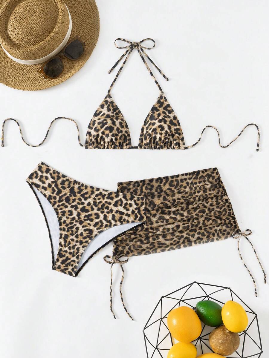 Women's black 3-piece bikini set featuring a halter triangle top with removable padding, high-waisted bottoms, and a knee-length mesh skirt with tie details.