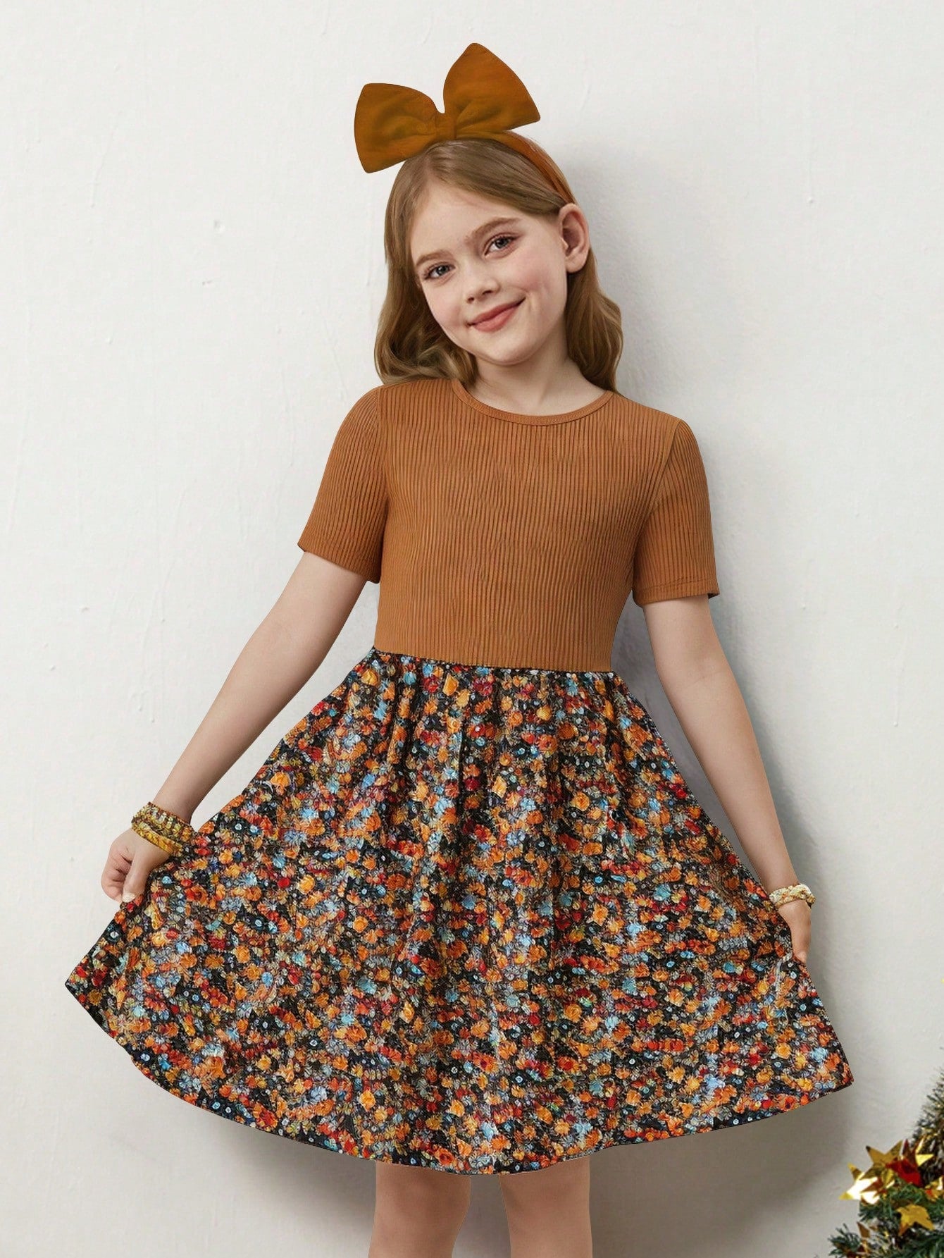 Tween girl wearing an apricot short sleeve A-line dress featuring a round neck, high waist with a belt, and flared hem.