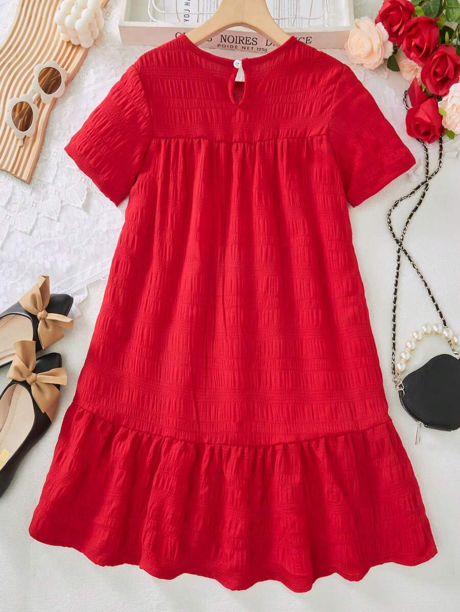 Tween girl wearing an Army Green textured short sleeve smock midi dress with round neck and ruffle flounce hem.