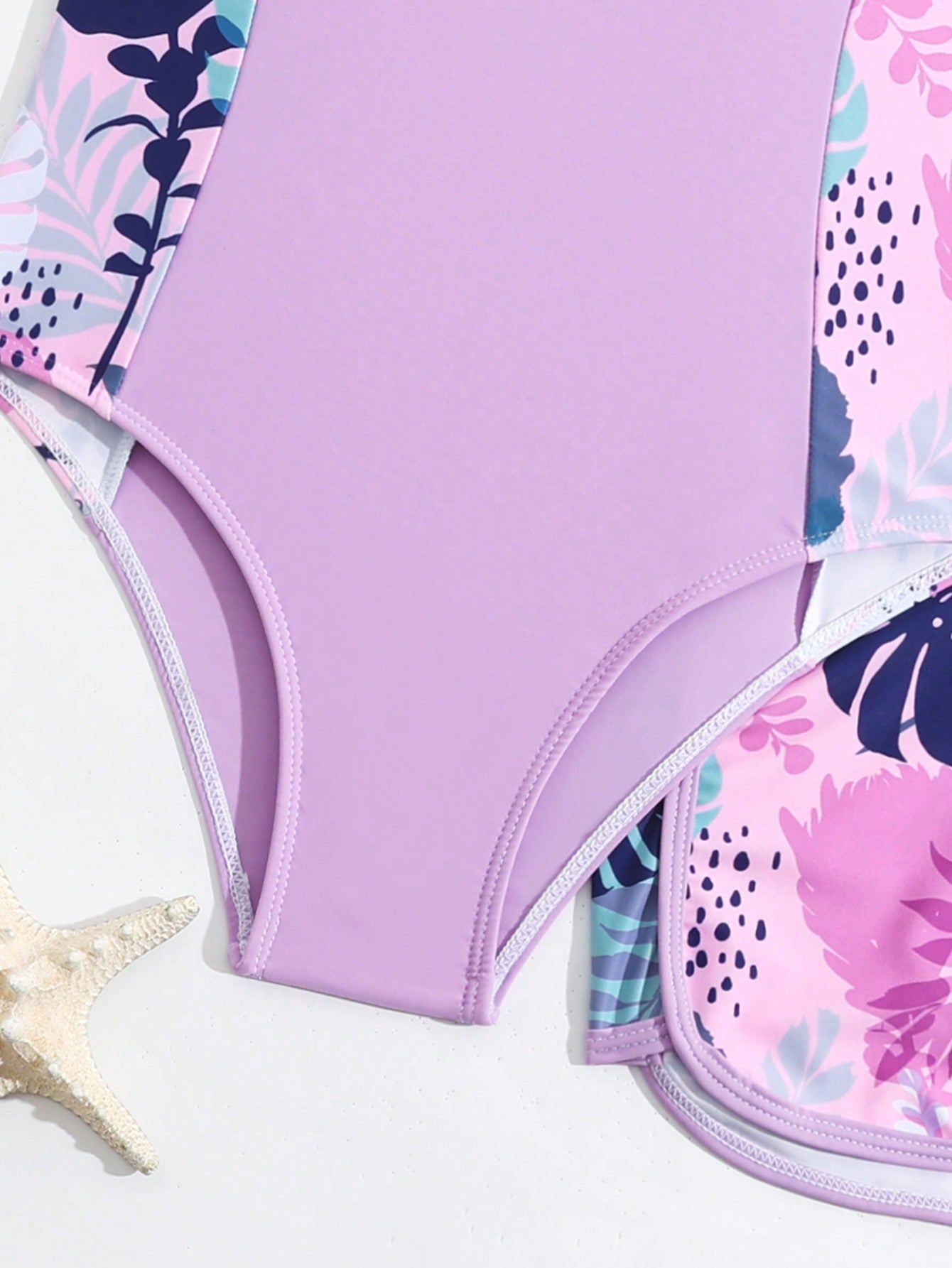 Tween girls 2-piece swimsuit set with a printed one-piece featuring ruffle trim, scoop neckline, cut-out detail, and matching shorts bottom.