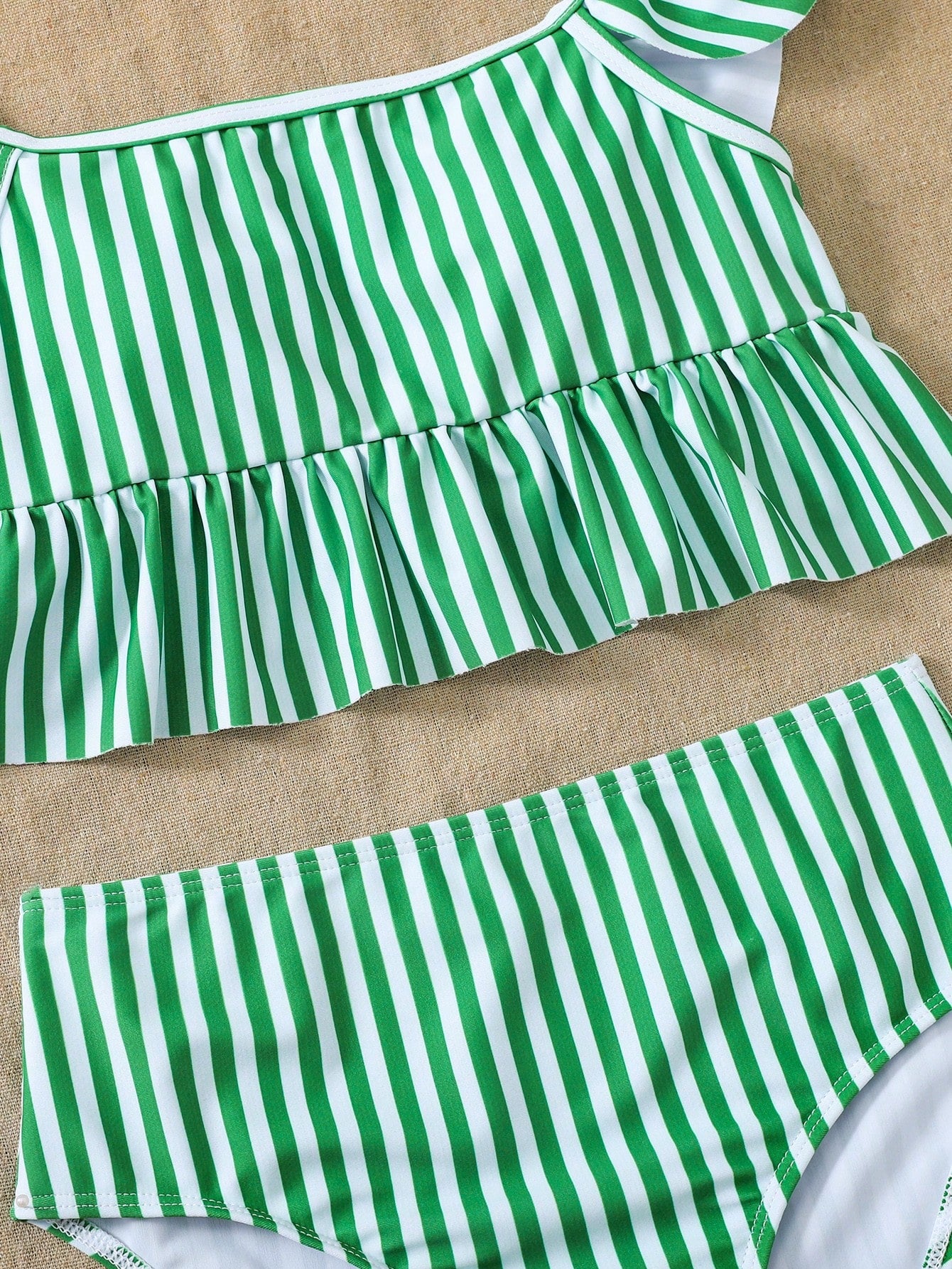 Girls striped tankini swimwear set with ruffle detail, square neckline, wireless top, and high-waist lined bottoms for beach and vacation wear.