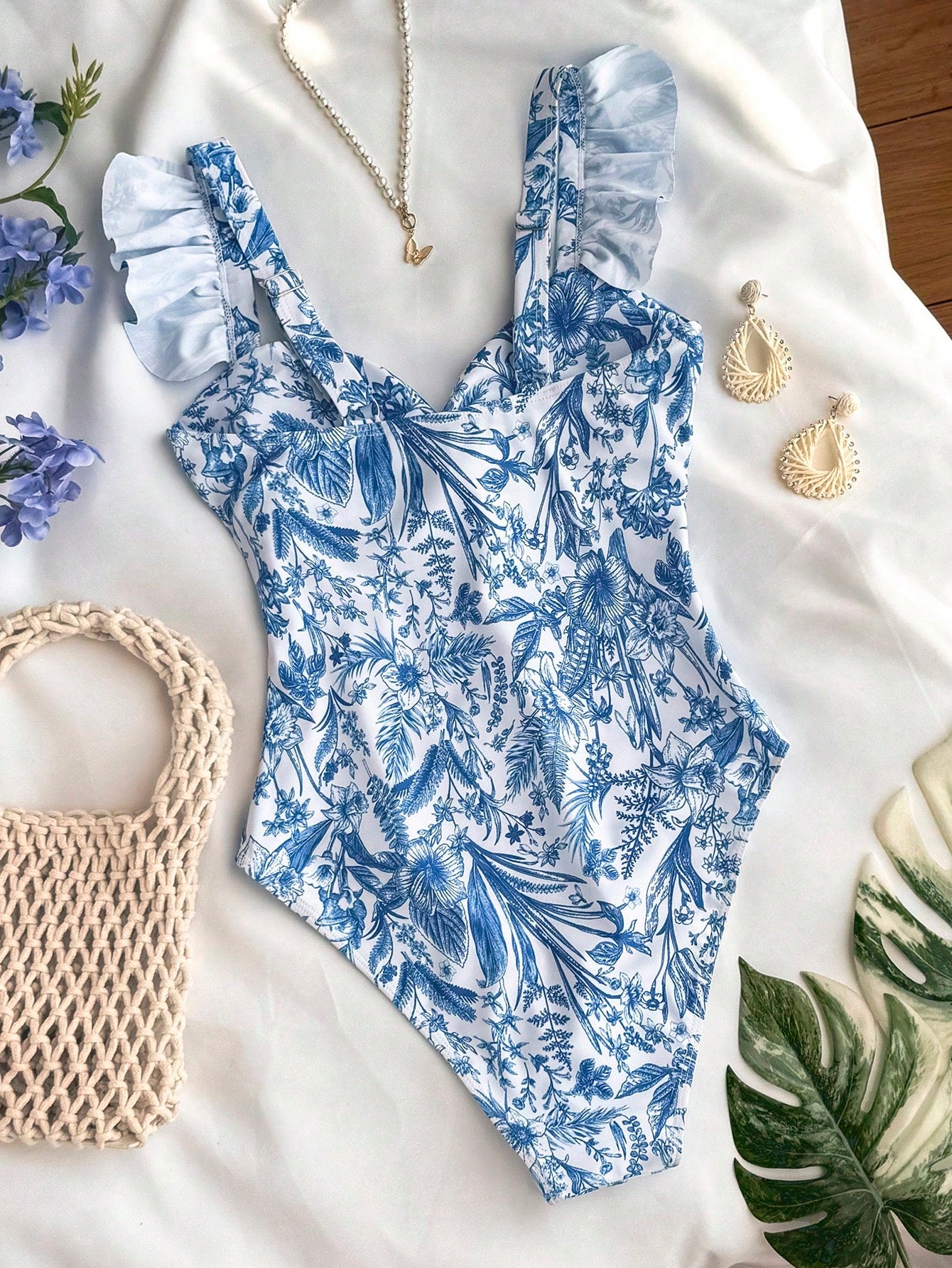 Tween girls blue and white floral print one-piece swimsuit with ruffle detail, spaghetti straps, V-neck styling, and vacation beachwear look.