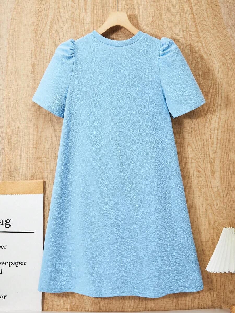 Tween girls apricot short-sleeve pleated smock dress with 3D bow decor and round neckline.