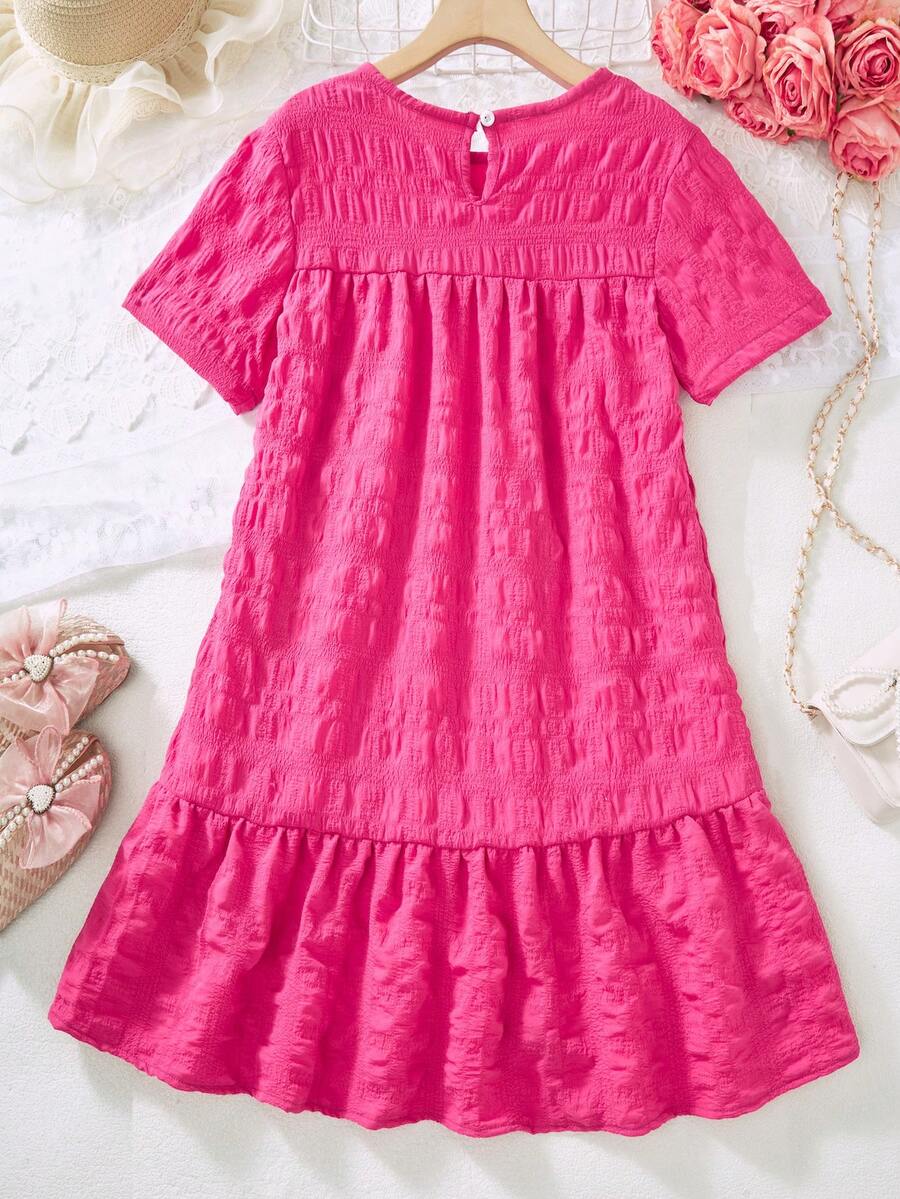 Tween girl wearing an Army Green textured short sleeve smock midi dress with round neck and ruffle flounce hem.