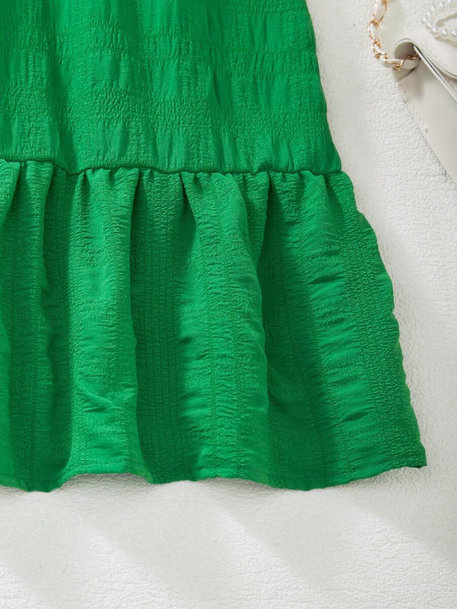 Tween girl wearing an Army Green textured short sleeve smock midi dress with round neck and ruffle flounce hem.