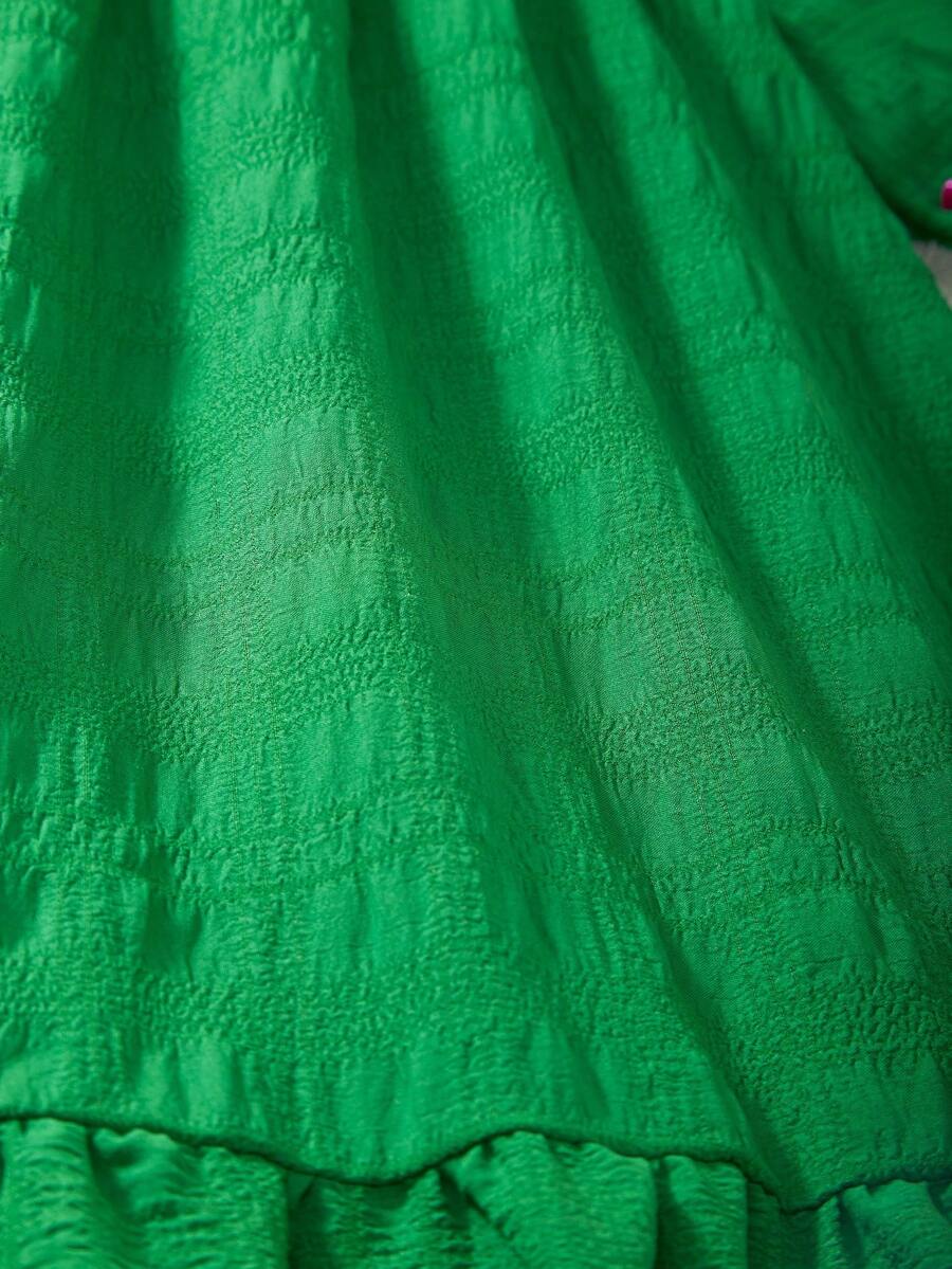 Tween girl wearing an Army Green textured short sleeve smock midi dress with round neck and ruffle flounce hem.