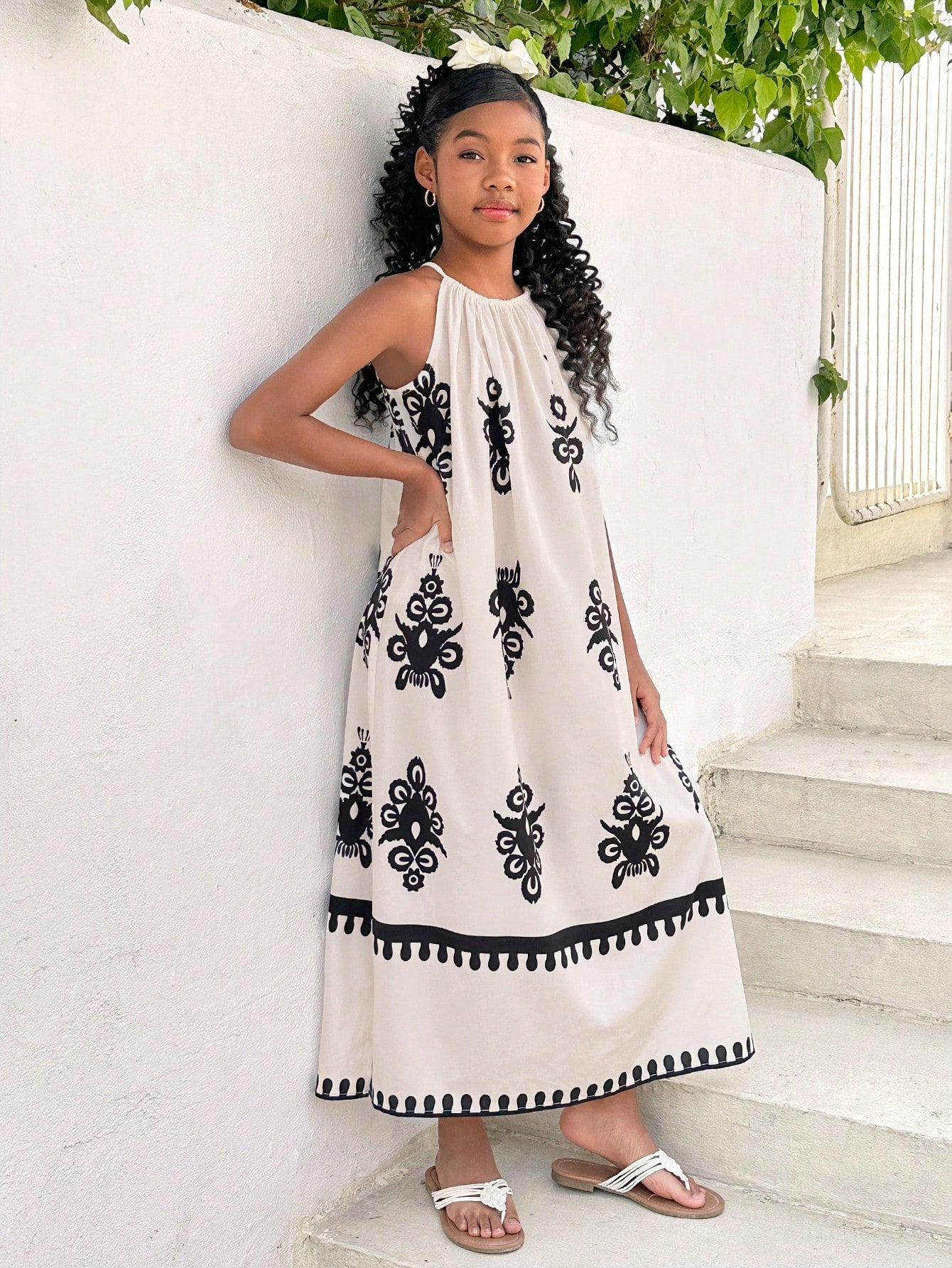 Tween girls green floral print cami dress with halter neckline, sleeveless cut, zipper detail, flared hem, and long vacation style silhouette.