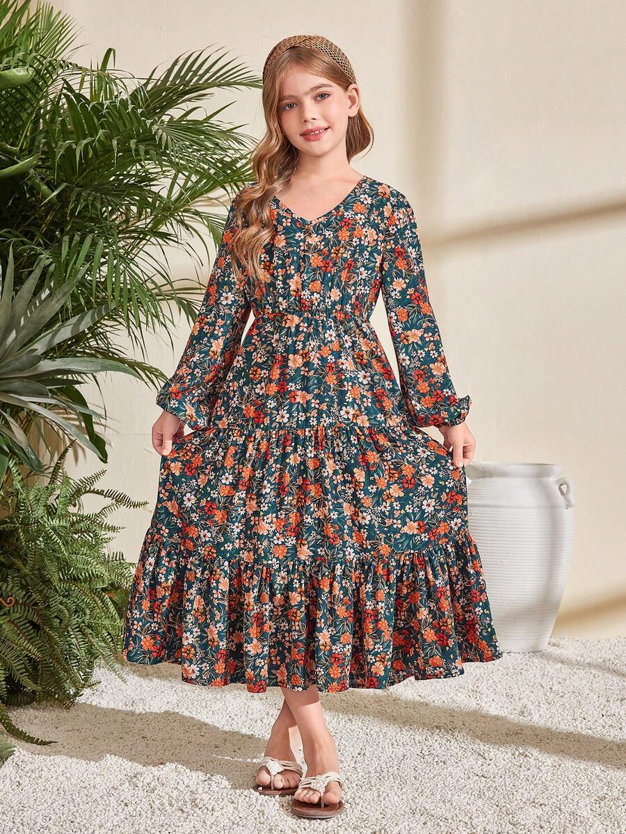 Tween girl wearing an apricot ditsy floral V-neck midi dress with long bishop puff sleeves, tiered ruffle layers, and a flounce hem.