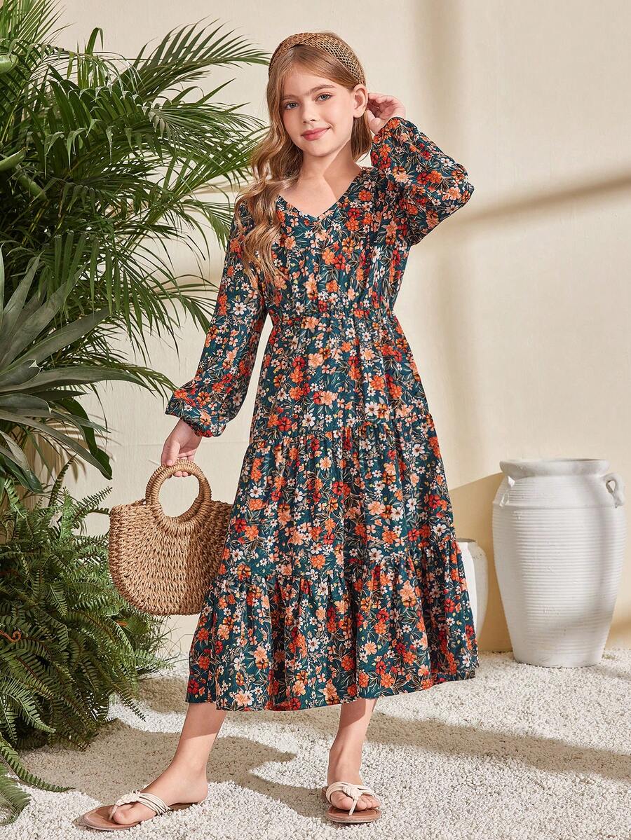 Tween girl wearing an apricot ditsy floral V-neck midi dress with long bishop puff sleeves, tiered ruffle layers, and a flounce hem.