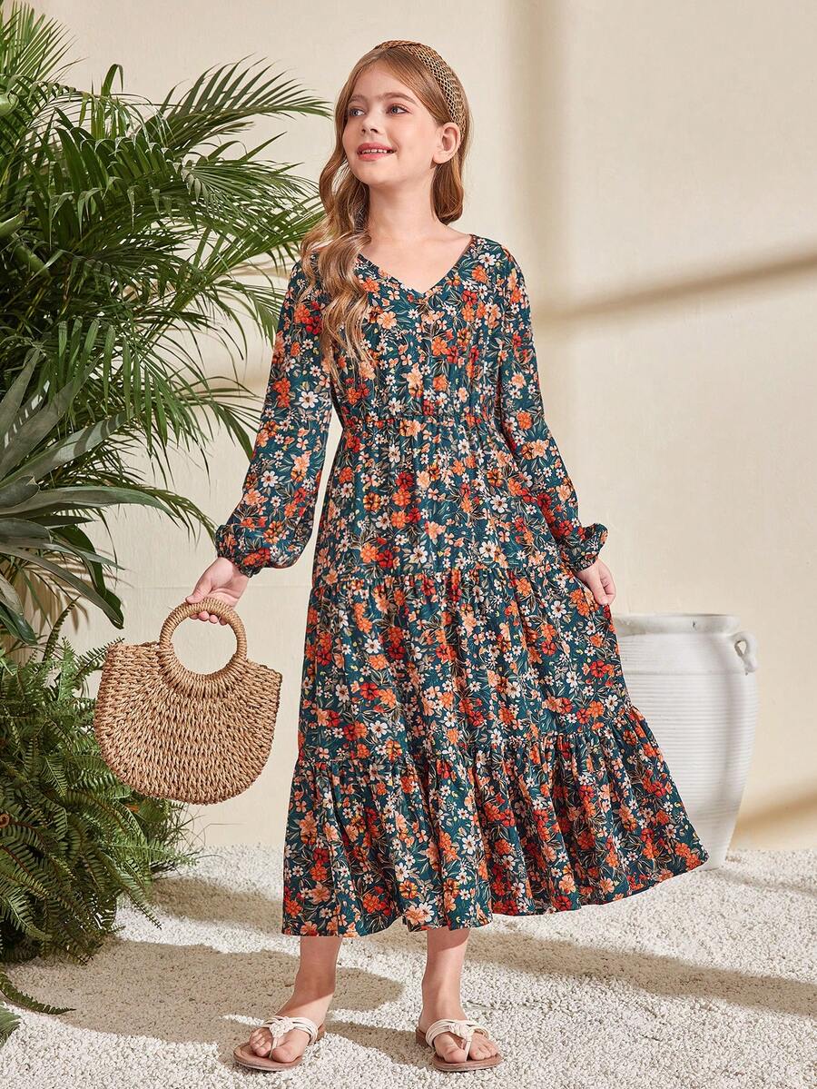 Tween girl wearing an apricot ditsy floral V-neck midi dress with long bishop puff sleeves, tiered ruffle layers, and a flounce hem.
