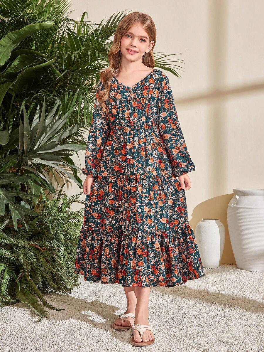 Tween girl wearing an apricot ditsy floral V-neck midi dress with long bishop puff sleeves, tiered ruffle layers, and a flounce hem.