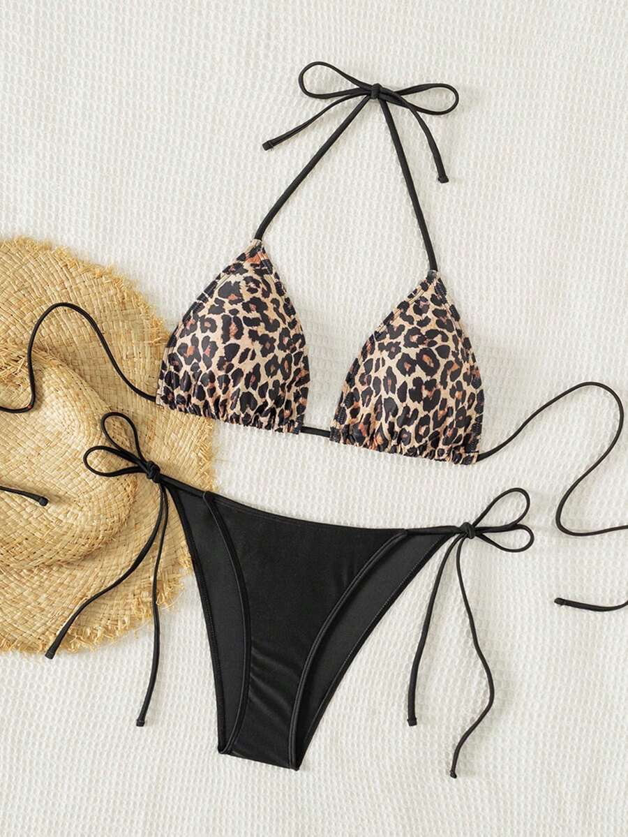Women's black two-piece bikini set featuring a halter neck with a colorful sun pendant, triangle cups, and high-cut tie-side bottoms.