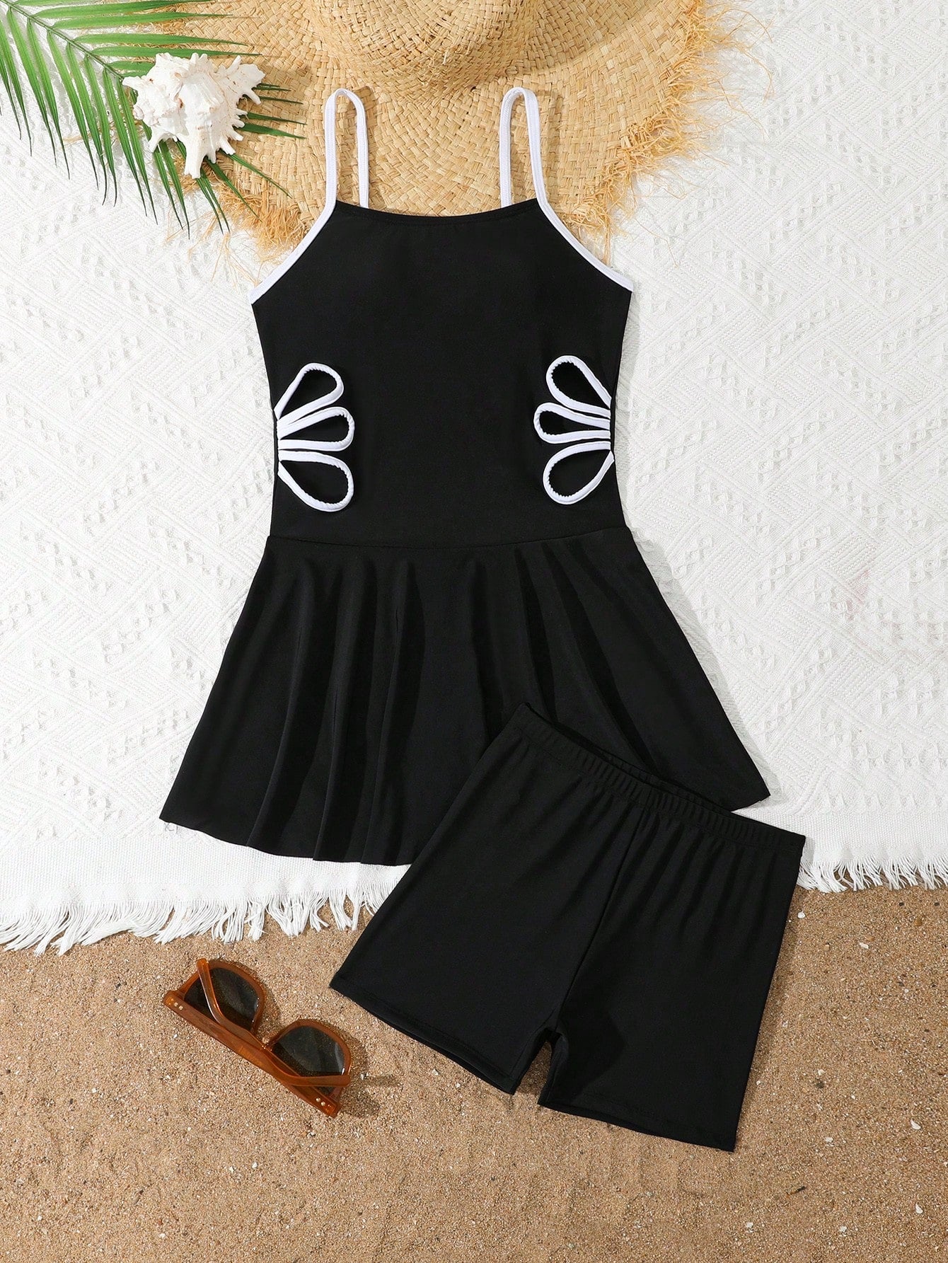 Tween girls black two-piece tankini swimwear set featuring a spaghetti strap sleeveless top with cutout detail and contrast piping, paired with short swim shorts.