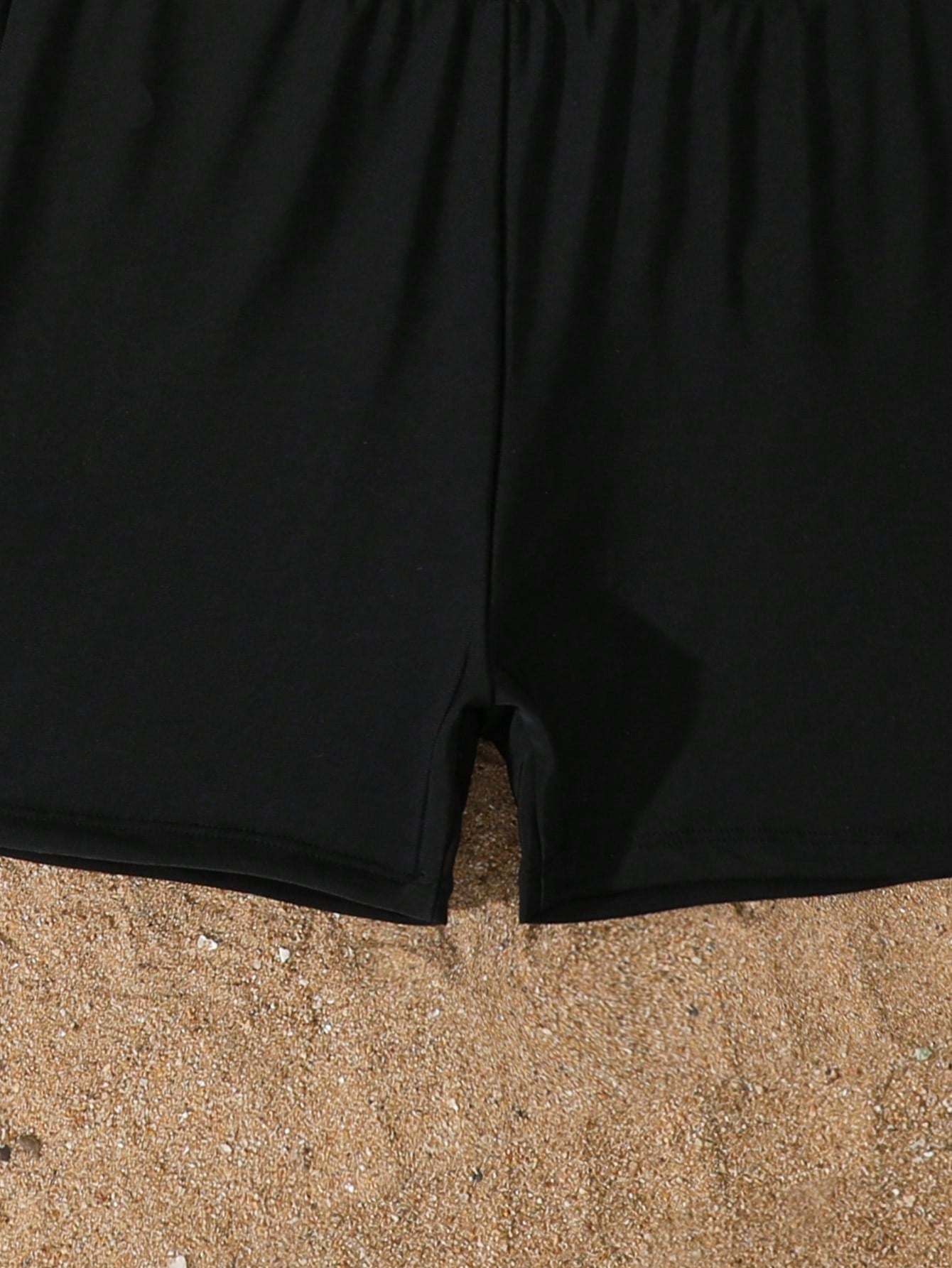 Tween girls black two-piece tankini swimwear set featuring a spaghetti strap sleeveless top with cutout detail and contrast piping, paired with short swim shorts.