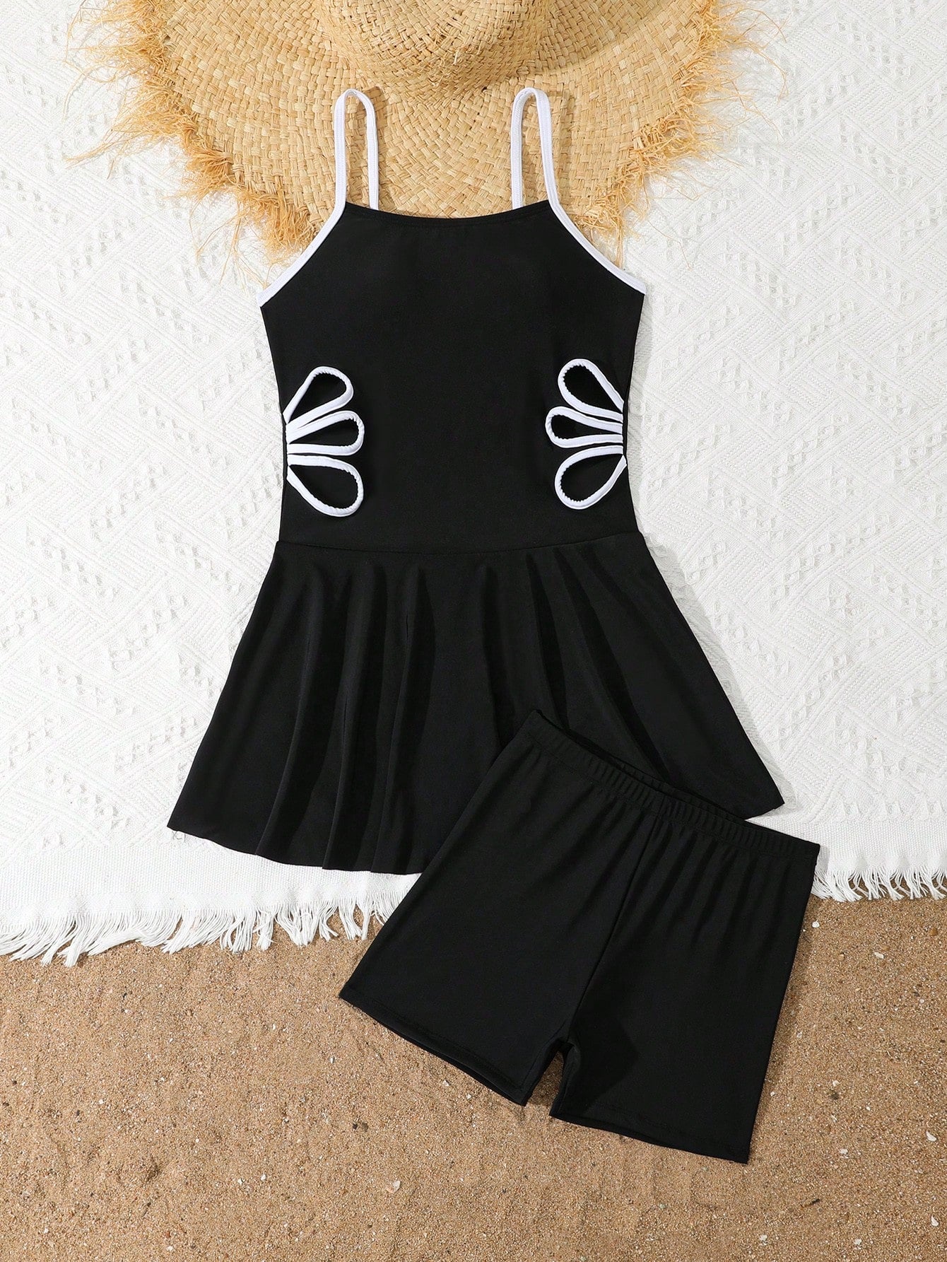 Tween girls black two-piece tankini swimwear set featuring a spaghetti strap sleeveless top with cutout detail and contrast piping, paired with short swim shorts.